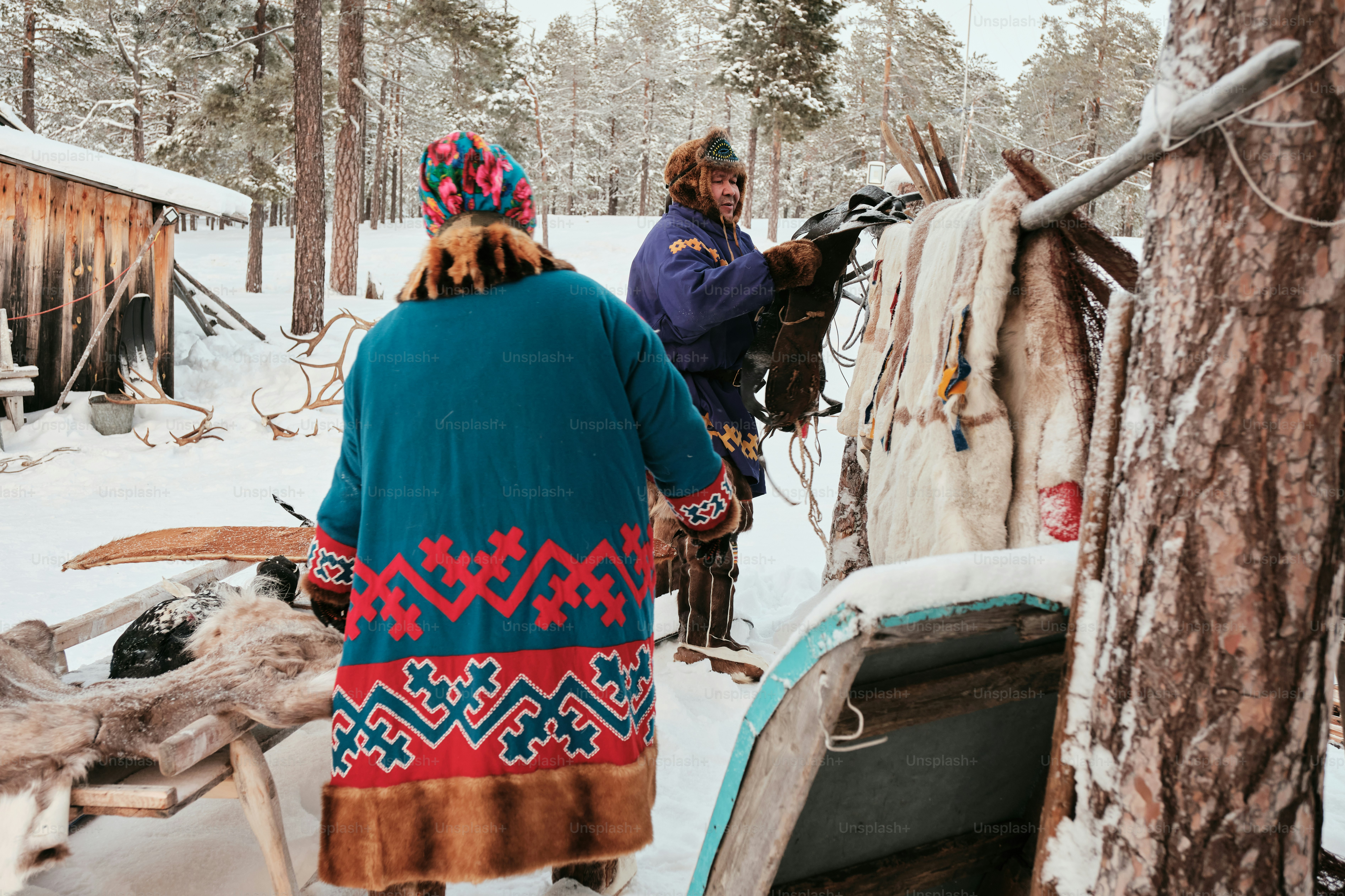 A woman standing next to a horse in the snow
