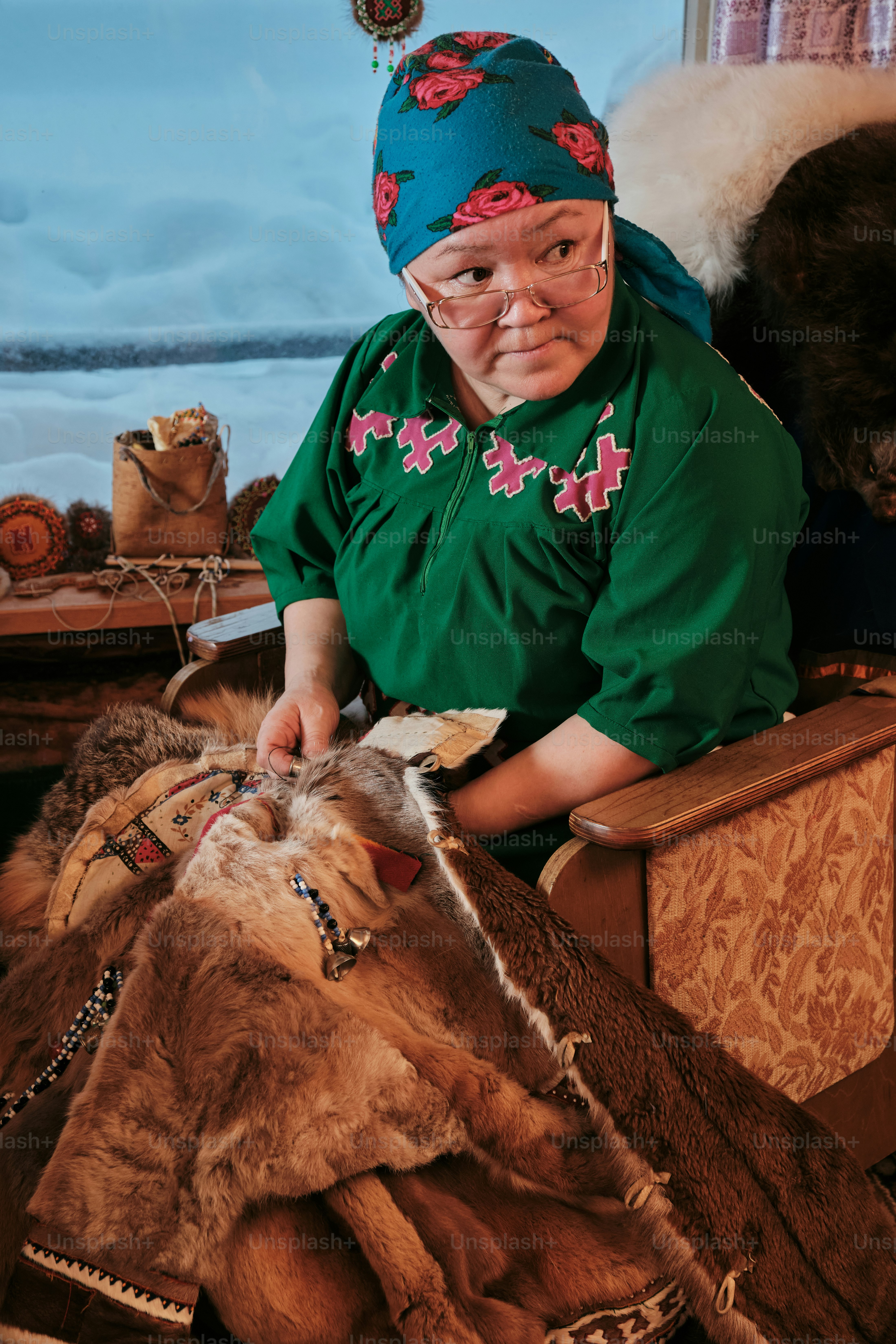 A woman in a green shirt petting a goat