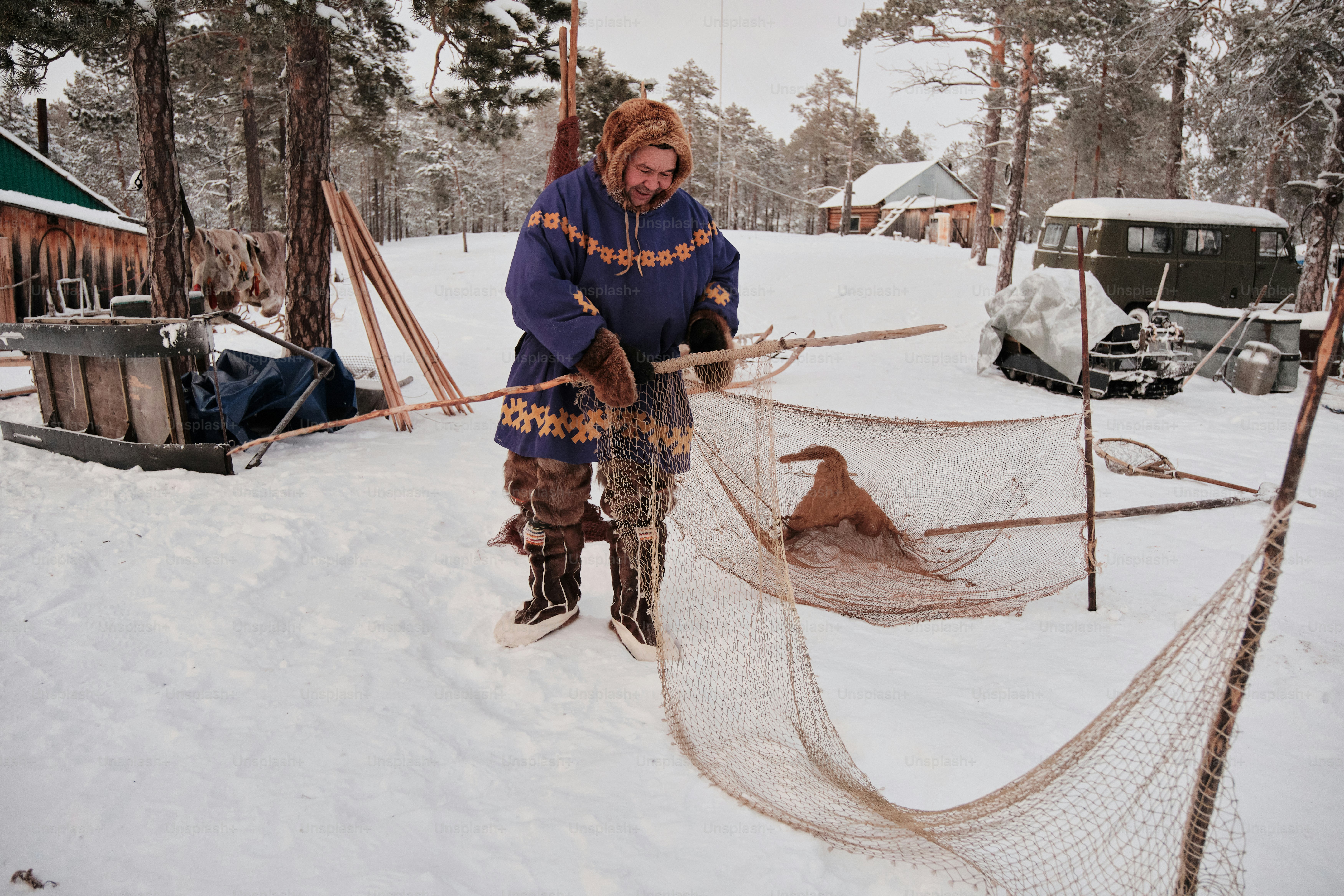 A man standing next to a net in the snow