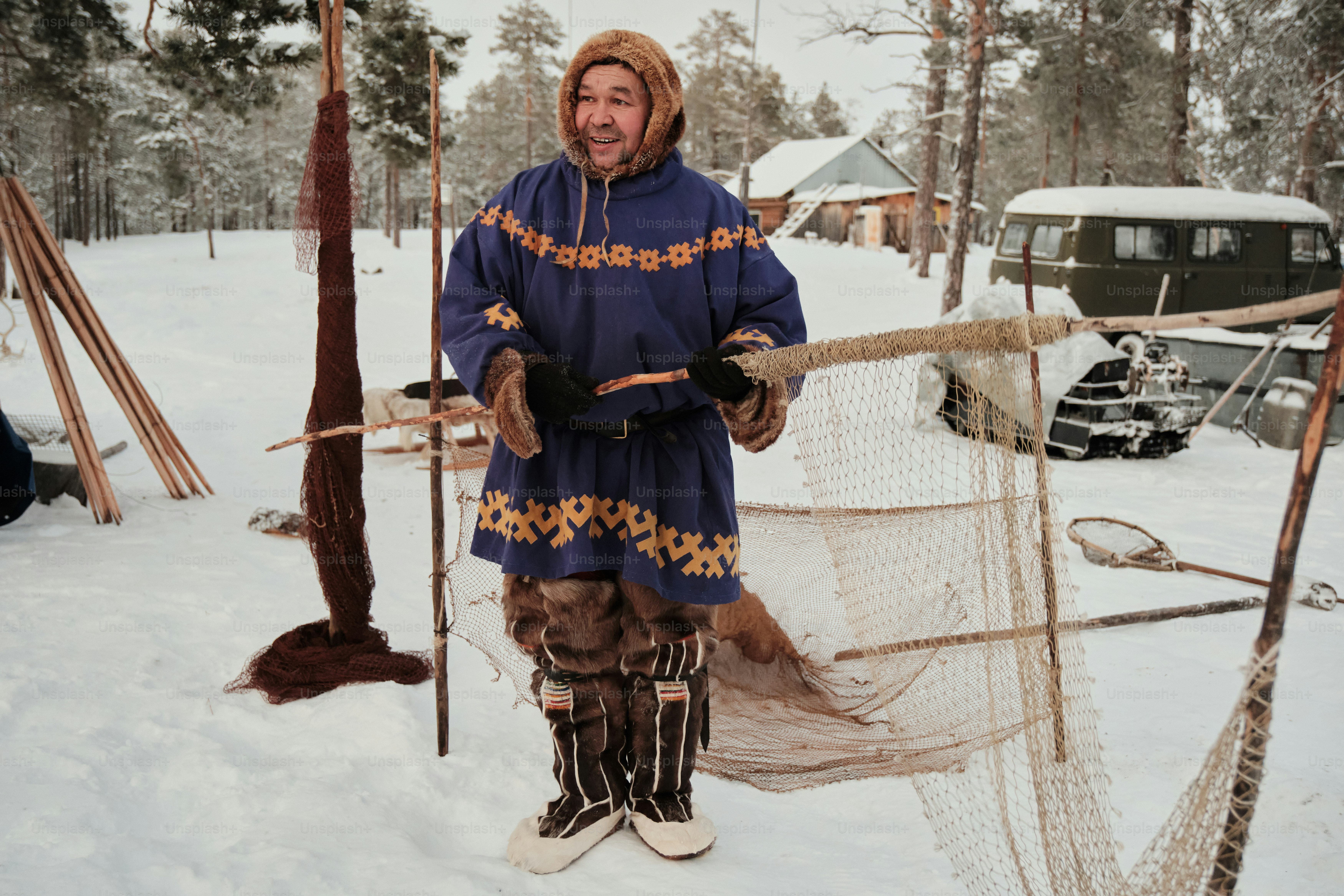 A man standing next to a net in the snow