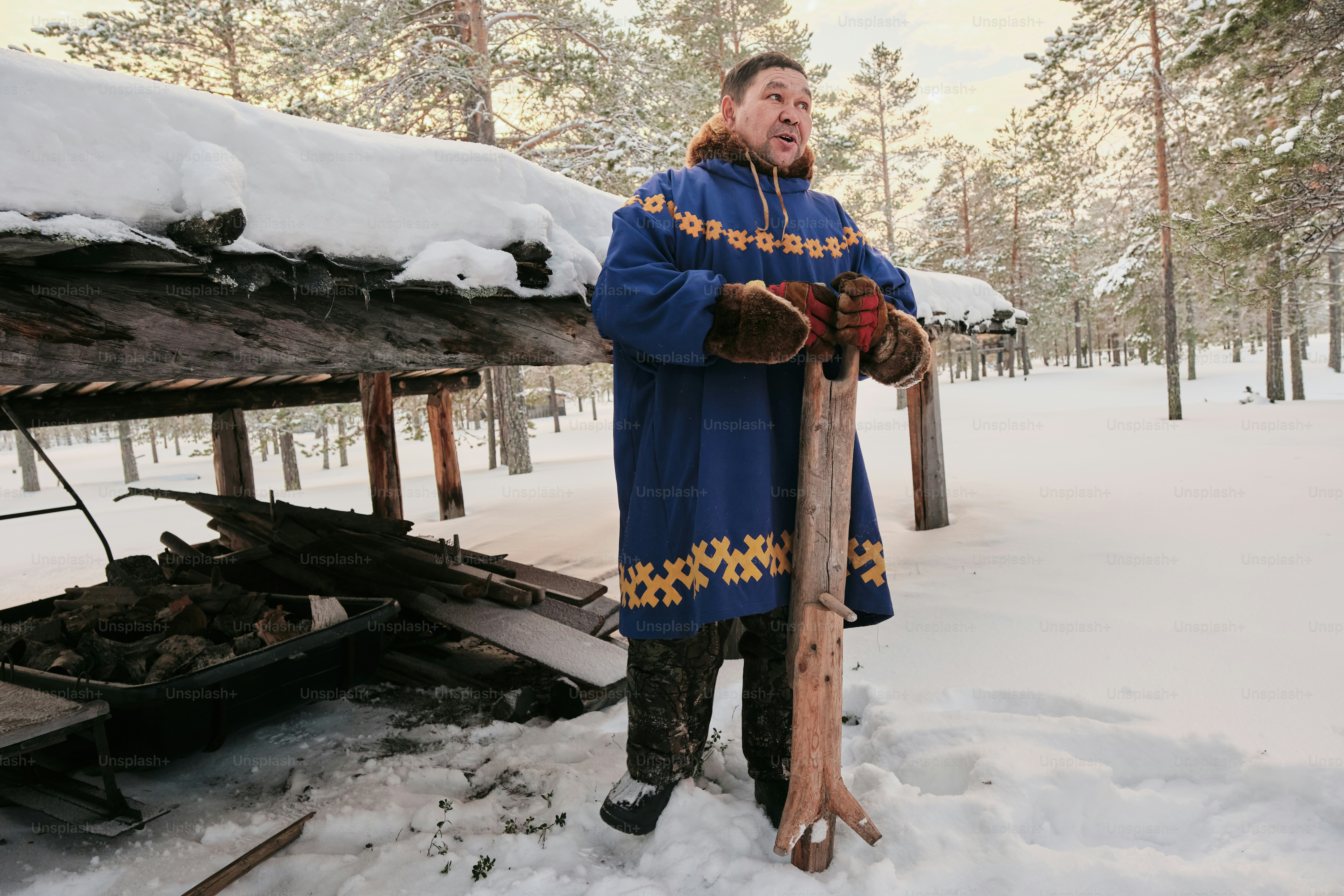 A man standing in the snow holding a stick