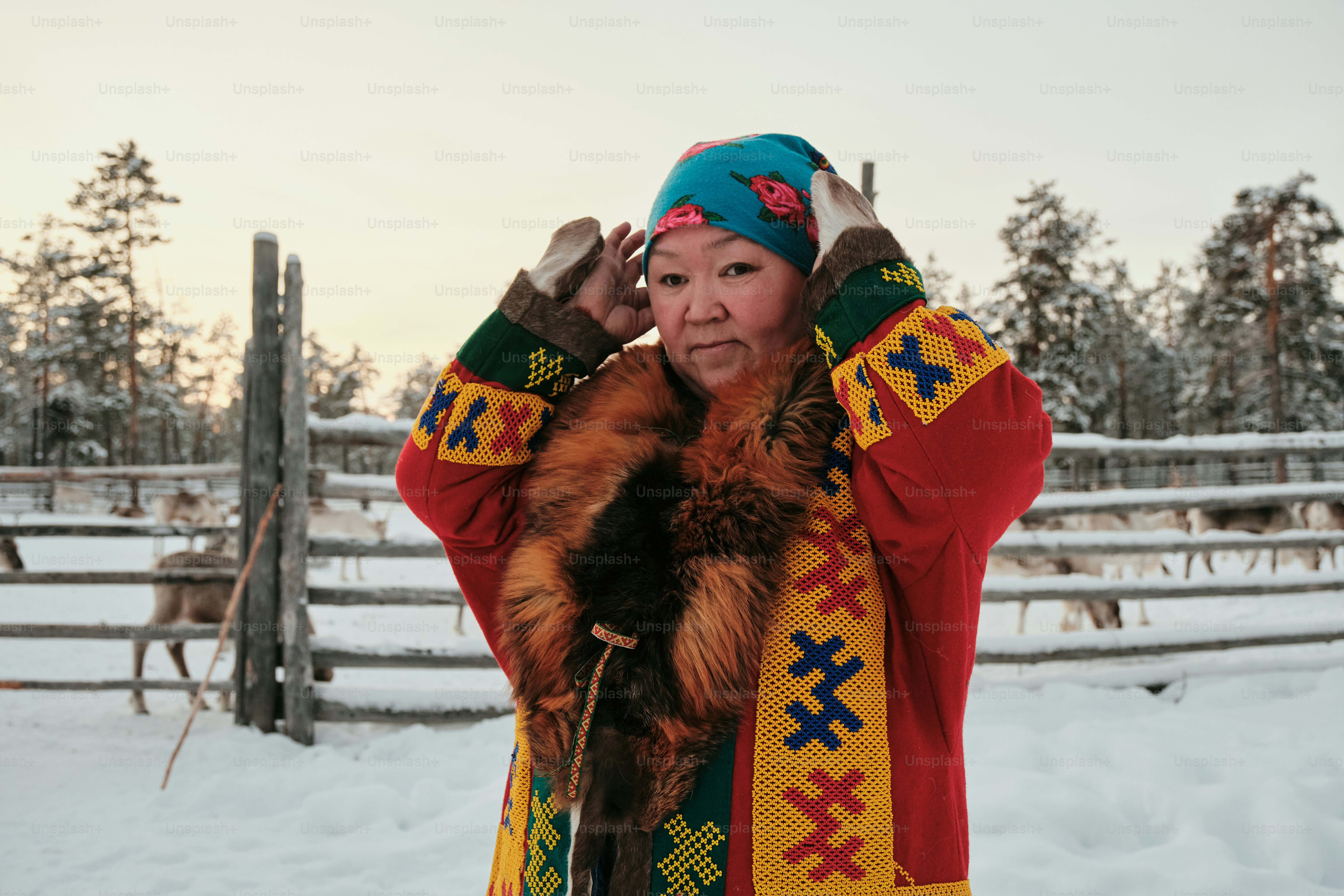 A woman standing in the snow talking on a cell phone