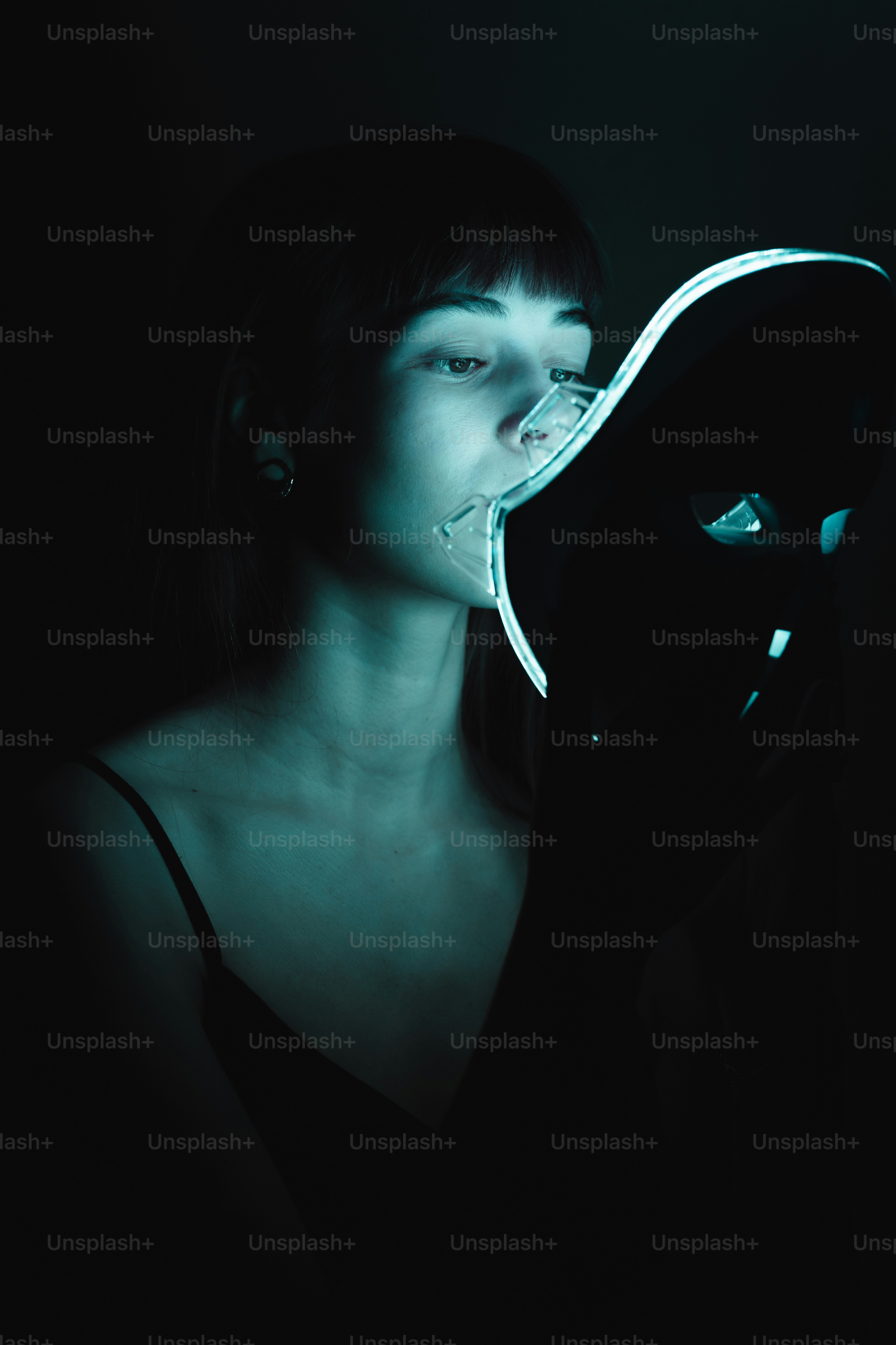 A woman wearing a white mask with her hands on her face photo ...