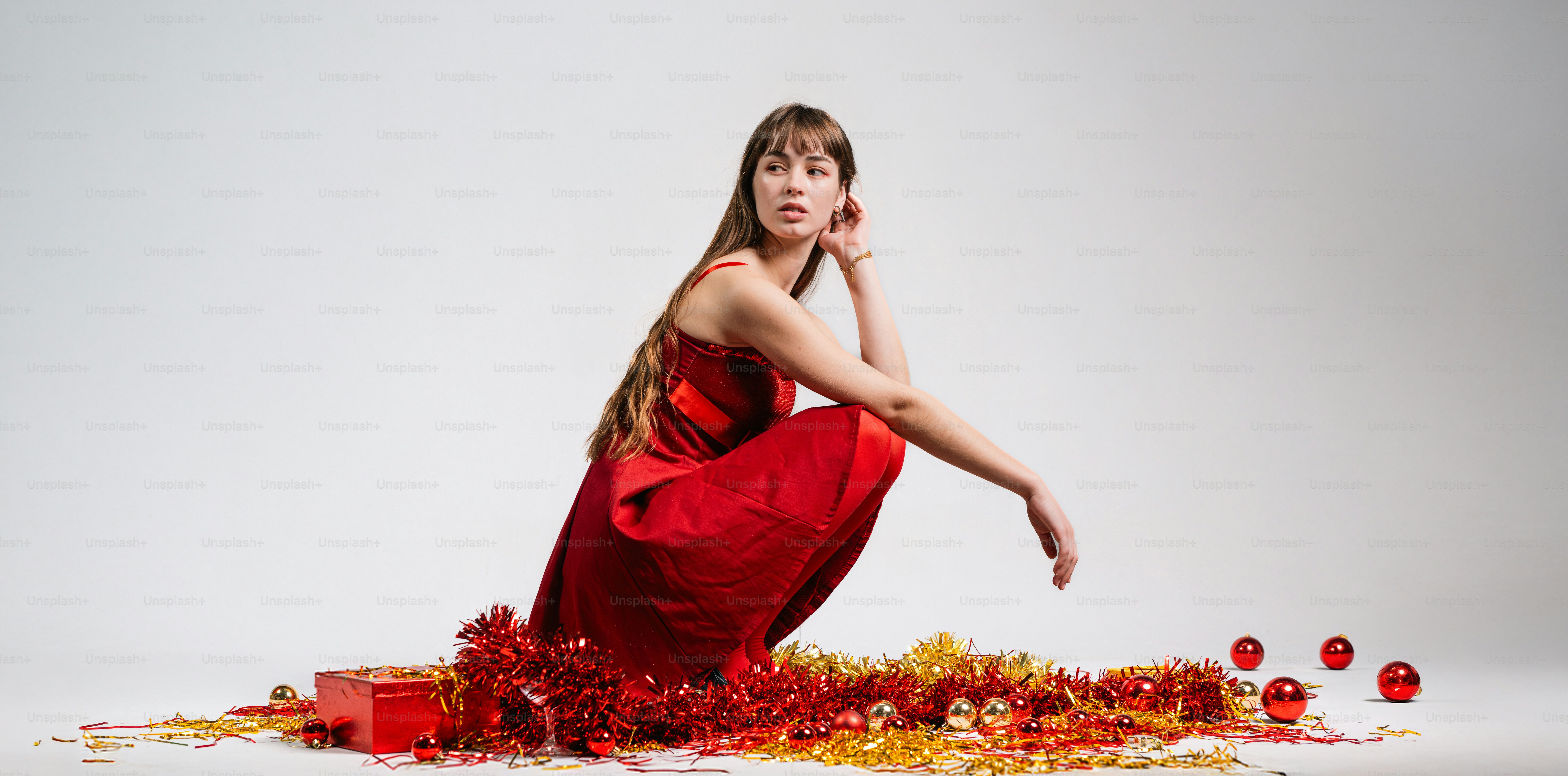 A woman in a red dress sitting on the floor