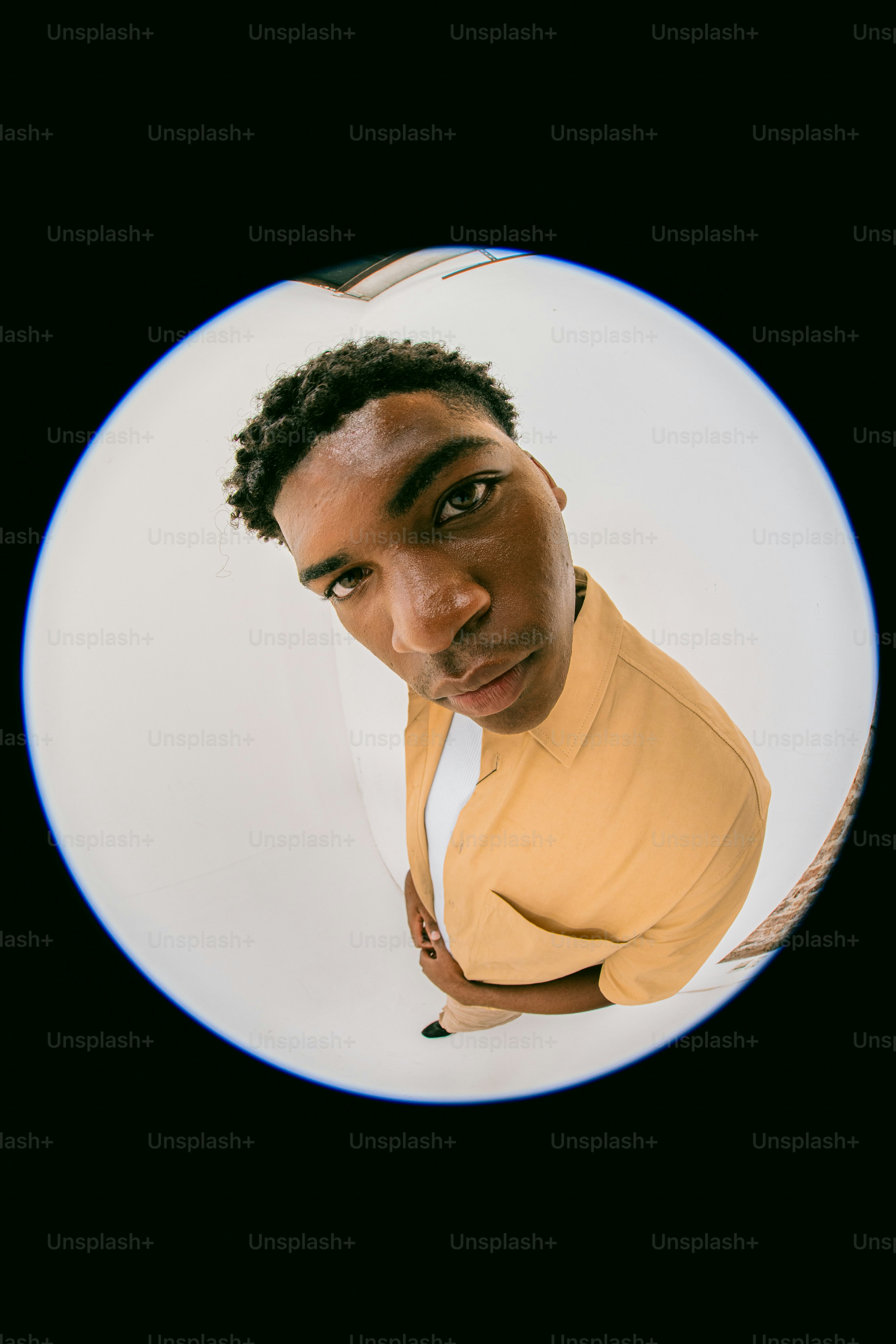 A man in a yellow shirt looking at the camera