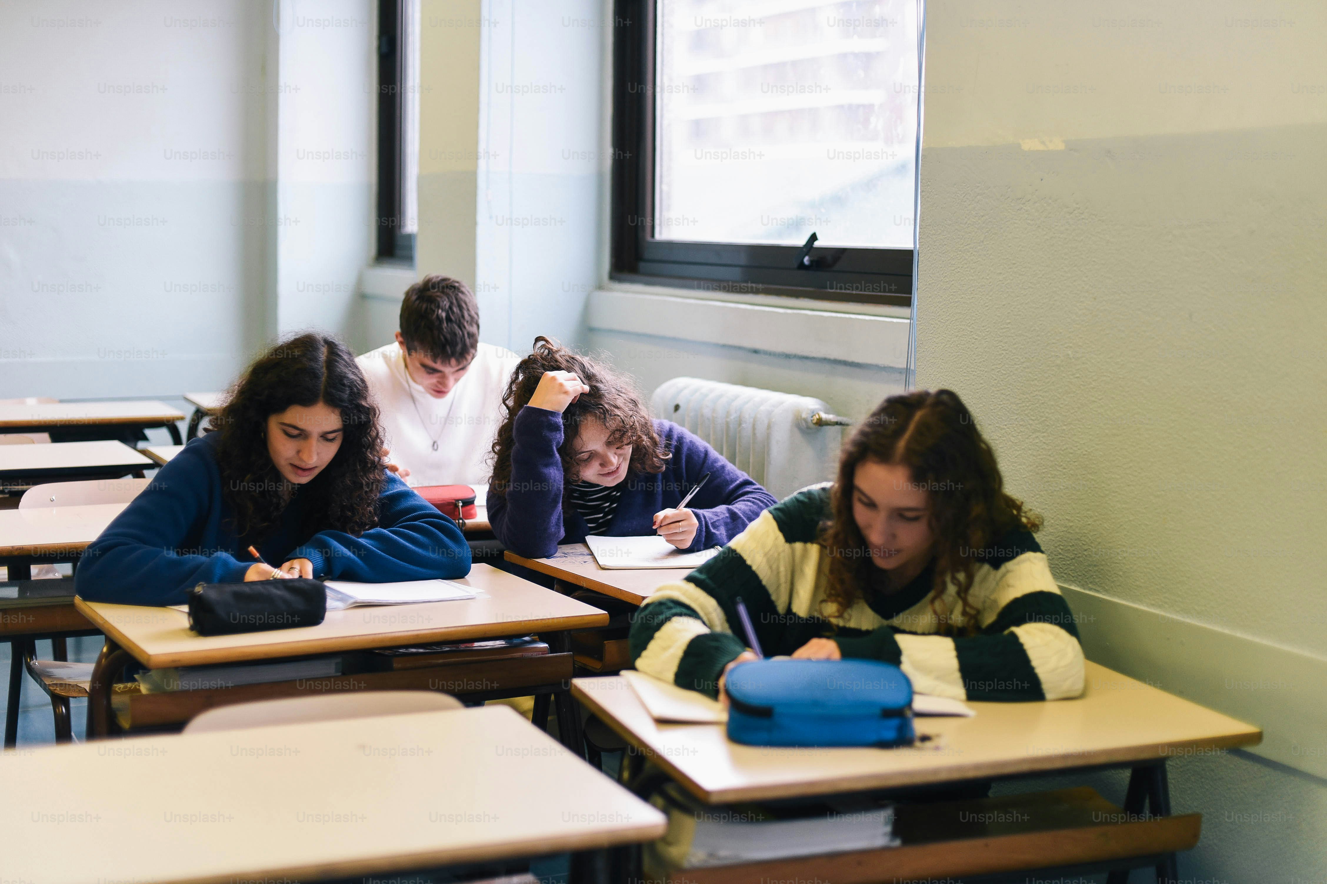 A group of people sitting at desks in a classroom