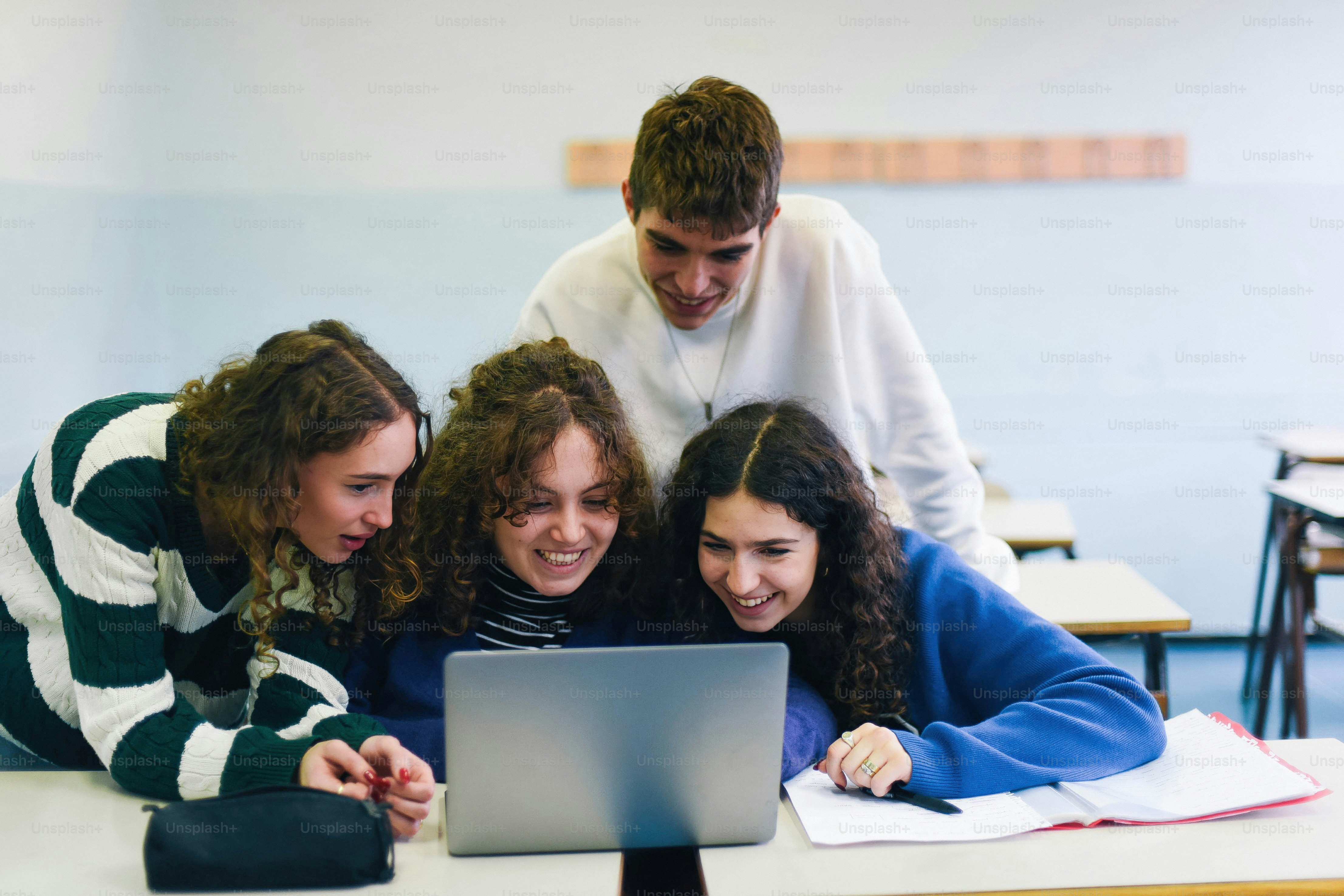 A group of young people looking at a laptop
