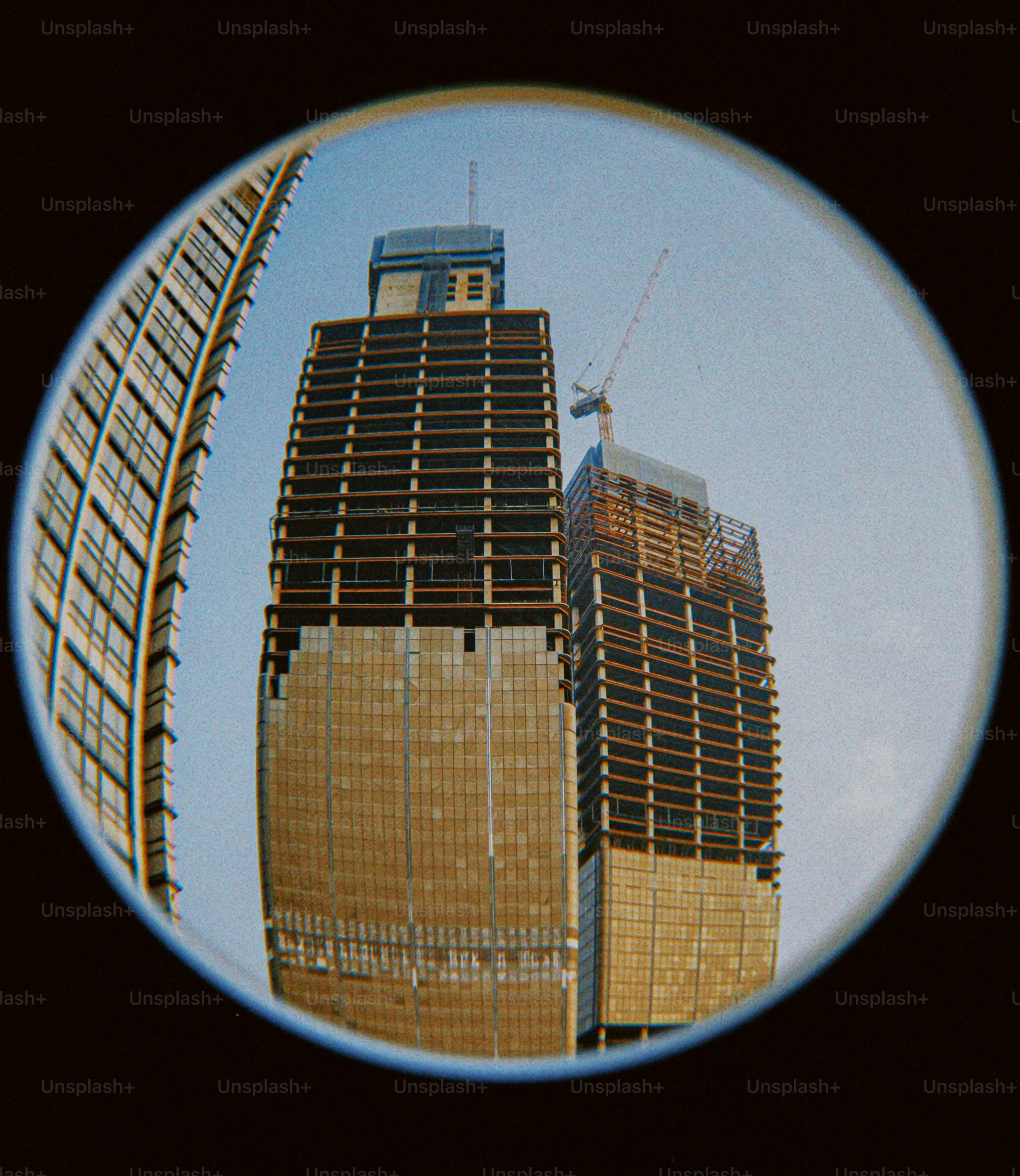 A circular picture of a building with a crane on top of it