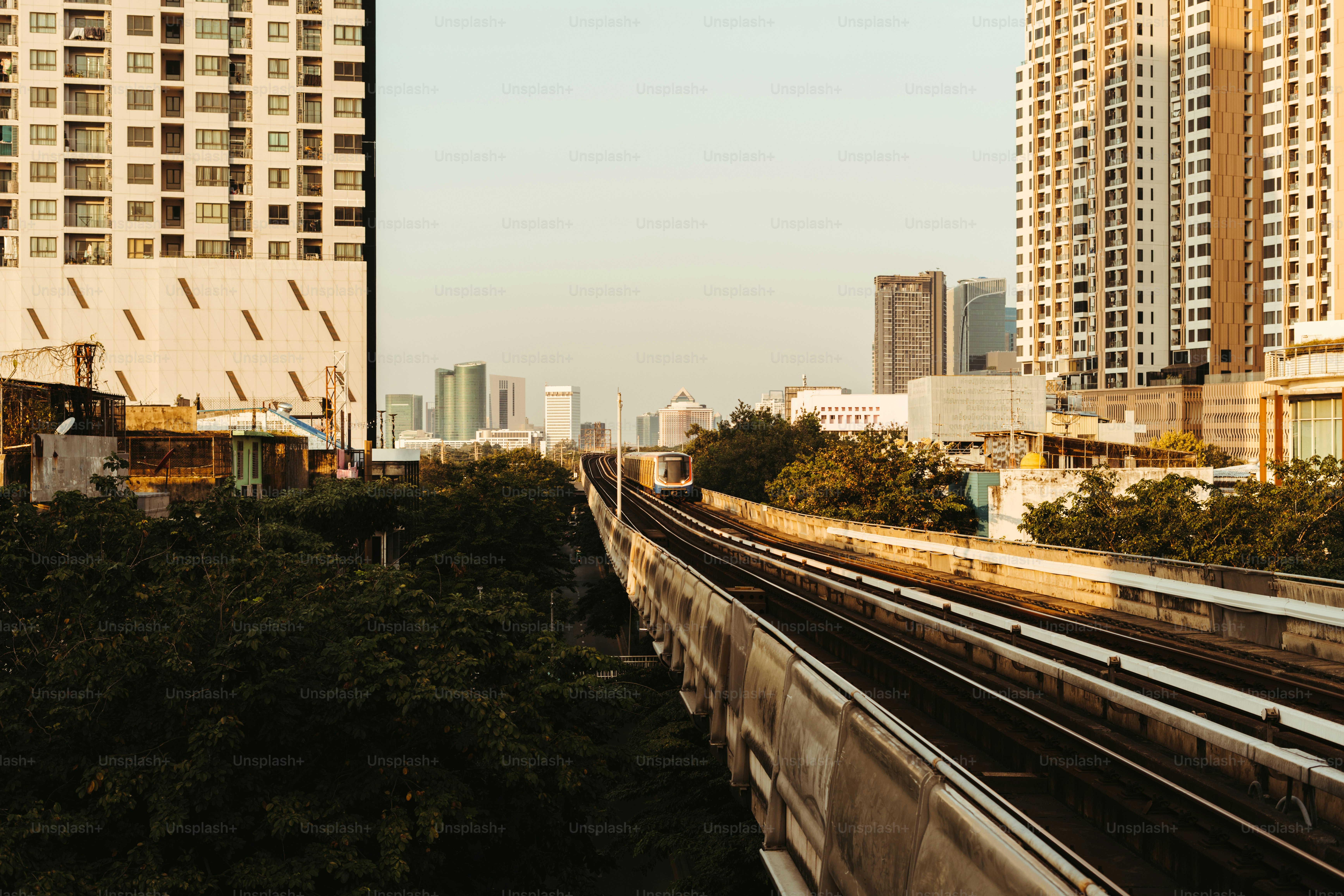 A train traveling through a city next to tall buildings