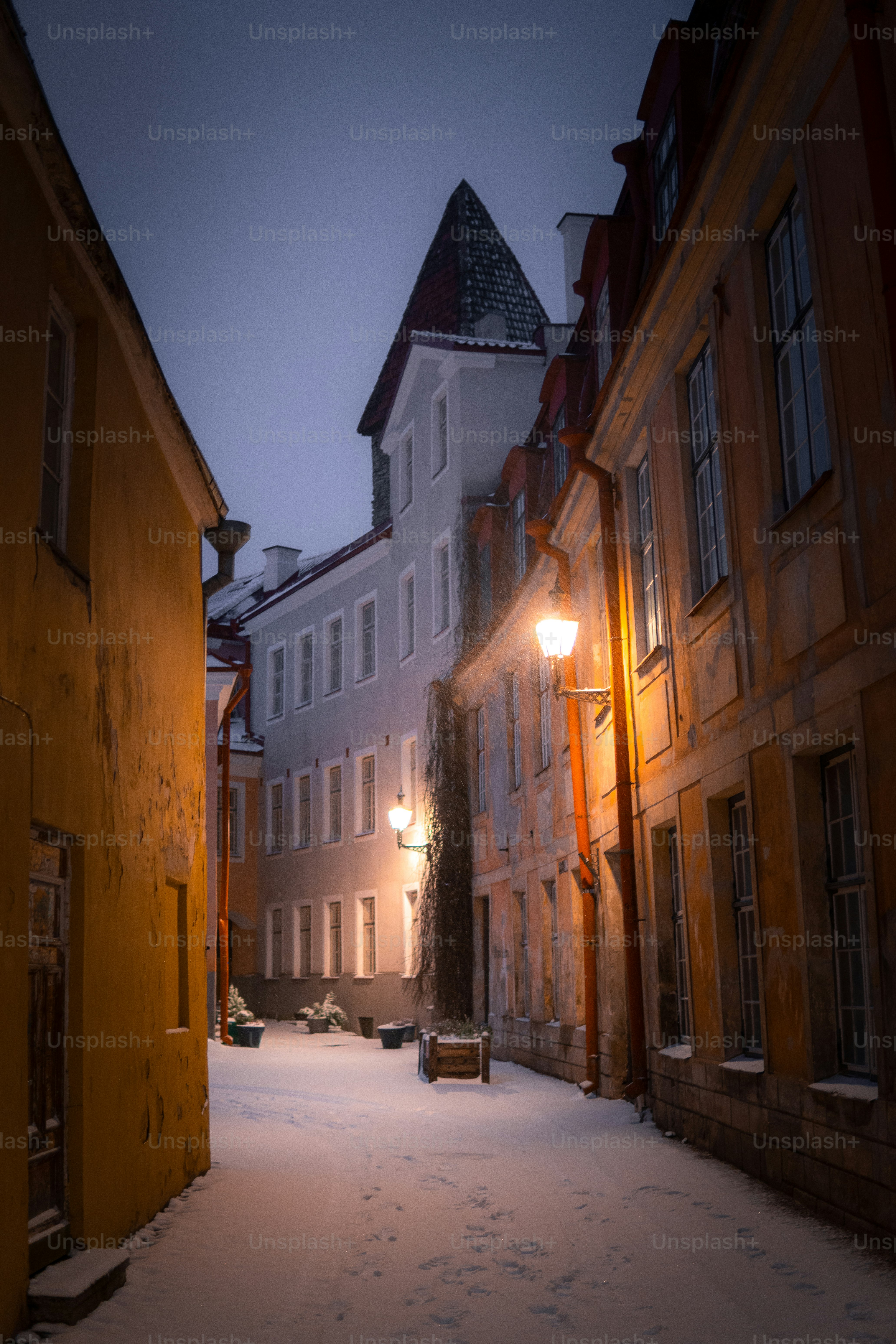 Un vicolo innevato con un lampione e palazzi
