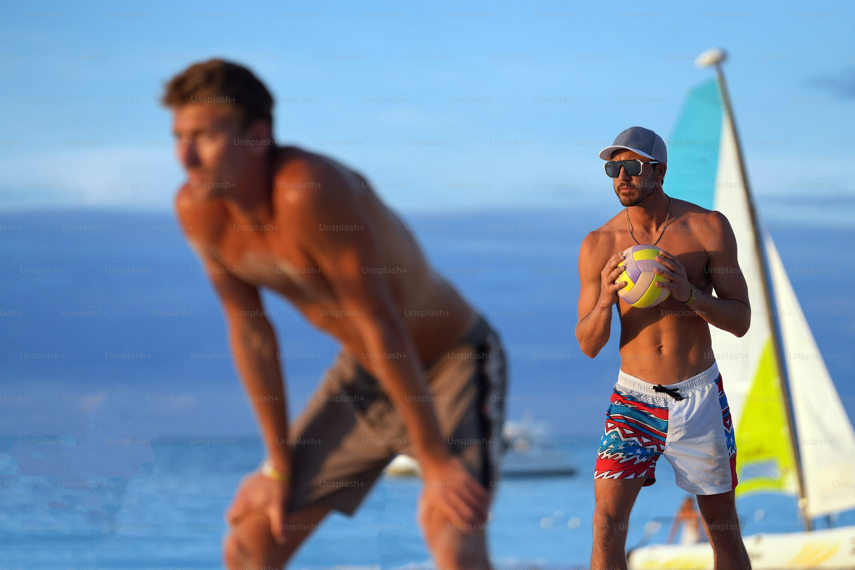 Un couple d’hommes debout au sommet d’une plage de sable