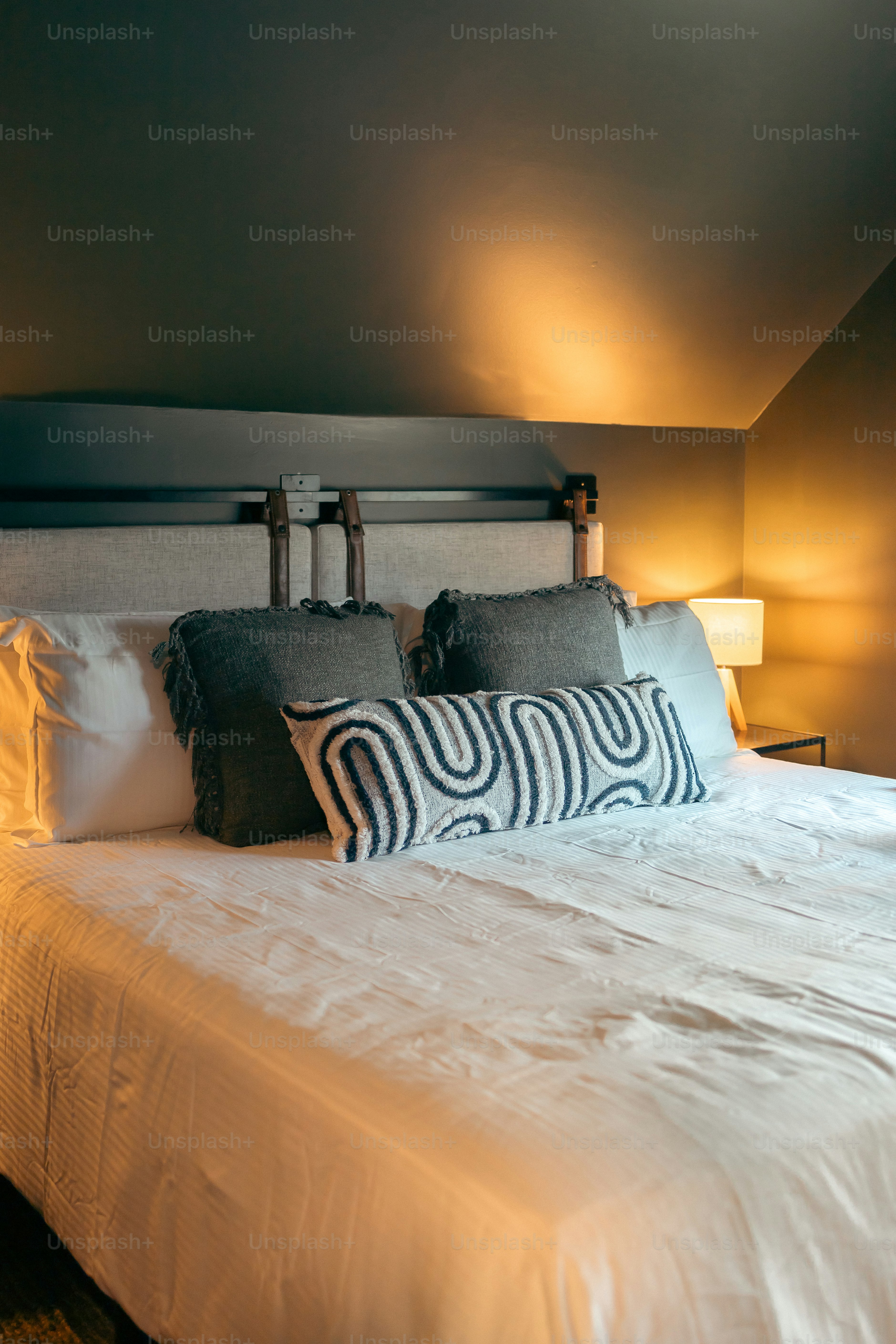 Une chambre avec un lit et deux lampes de chaque côté du lit