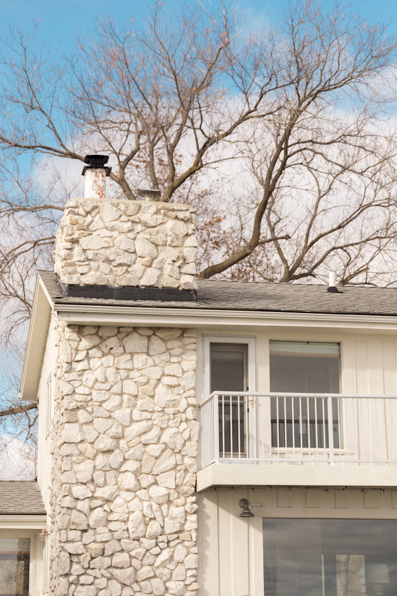 Stone-clad chimney rising above the roofline of a home