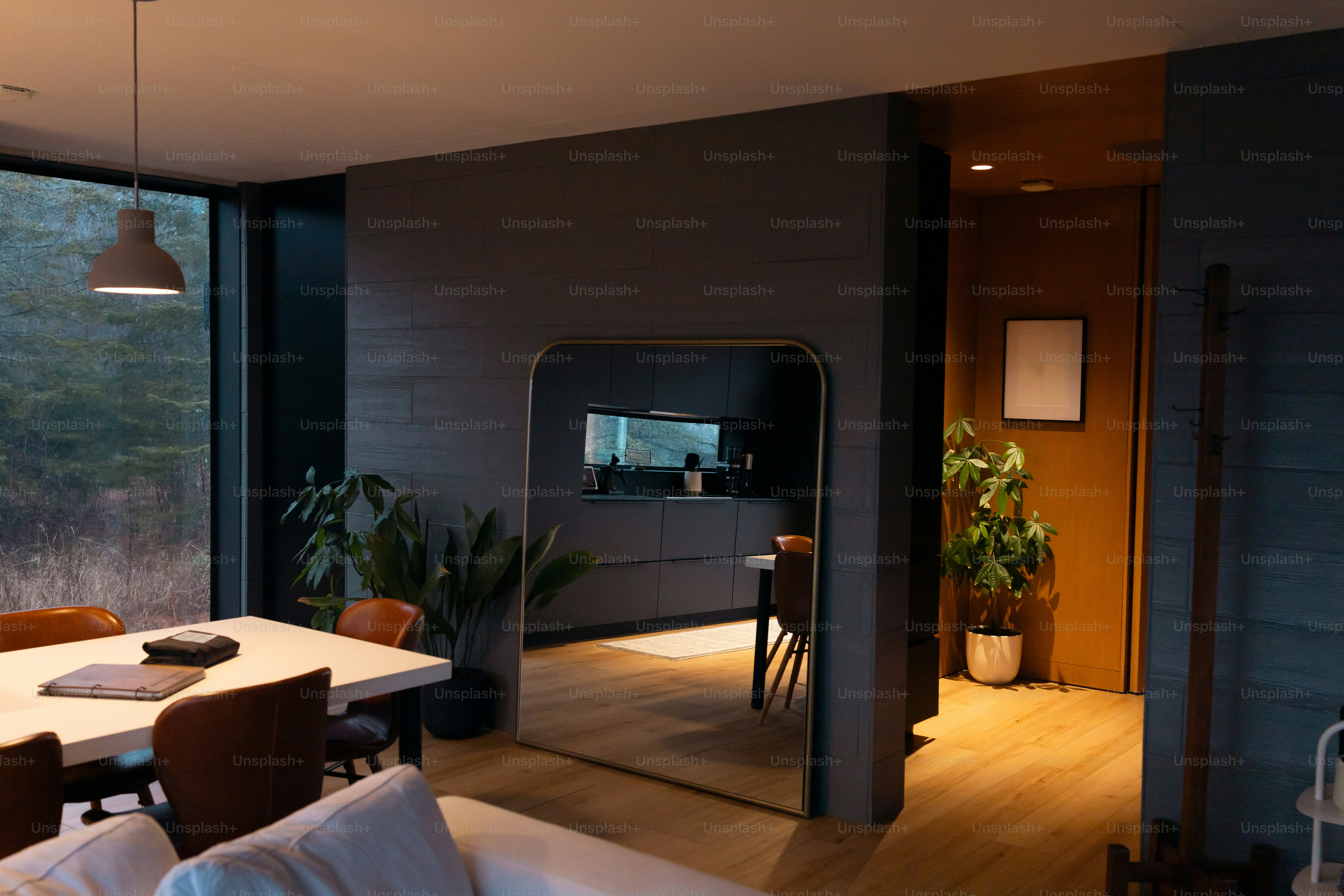 A living room with a large window and a dining table