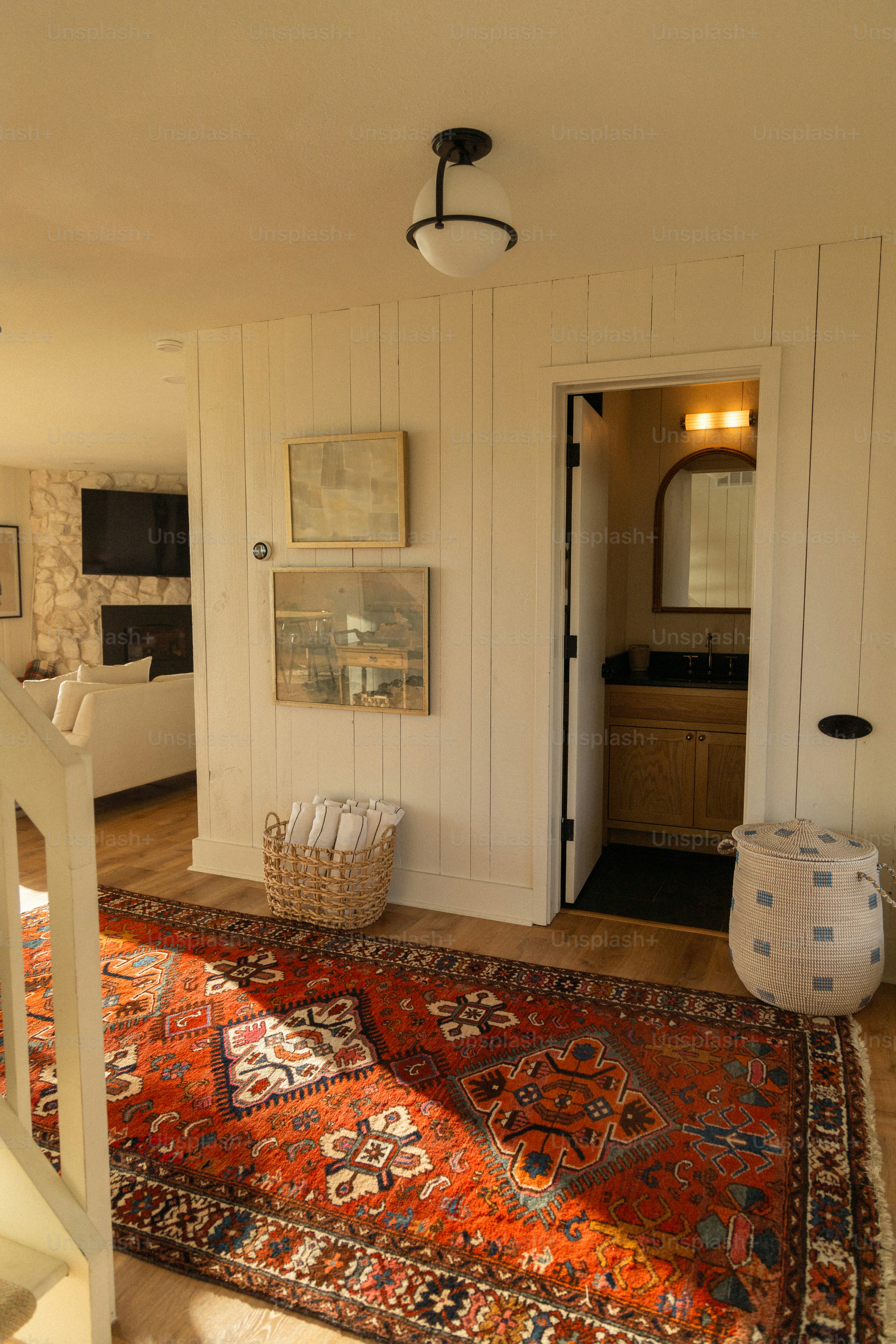 A living room with a rug and stairs