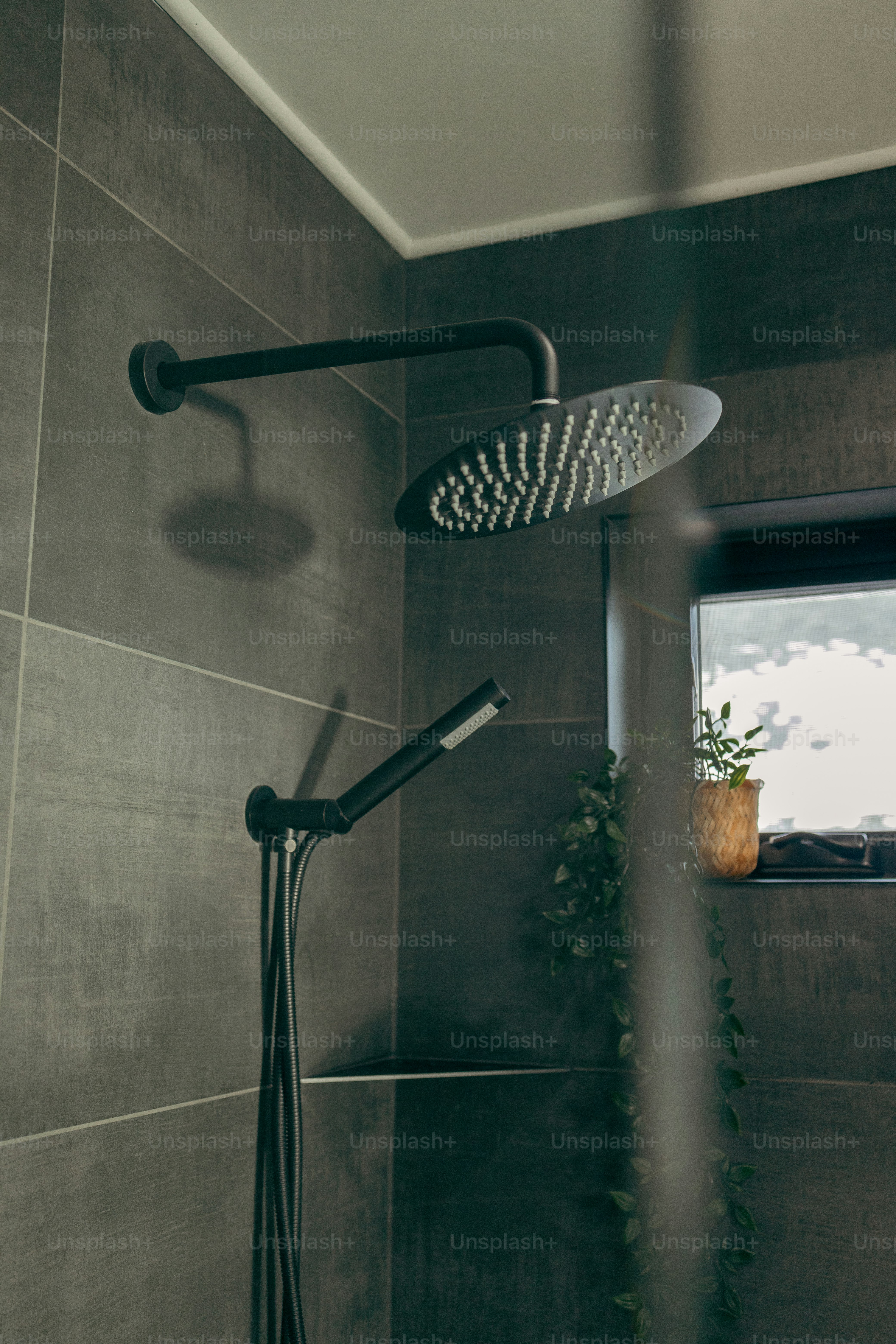 Ein Duschkopf in einem Badezimmer neben einem Fenster
