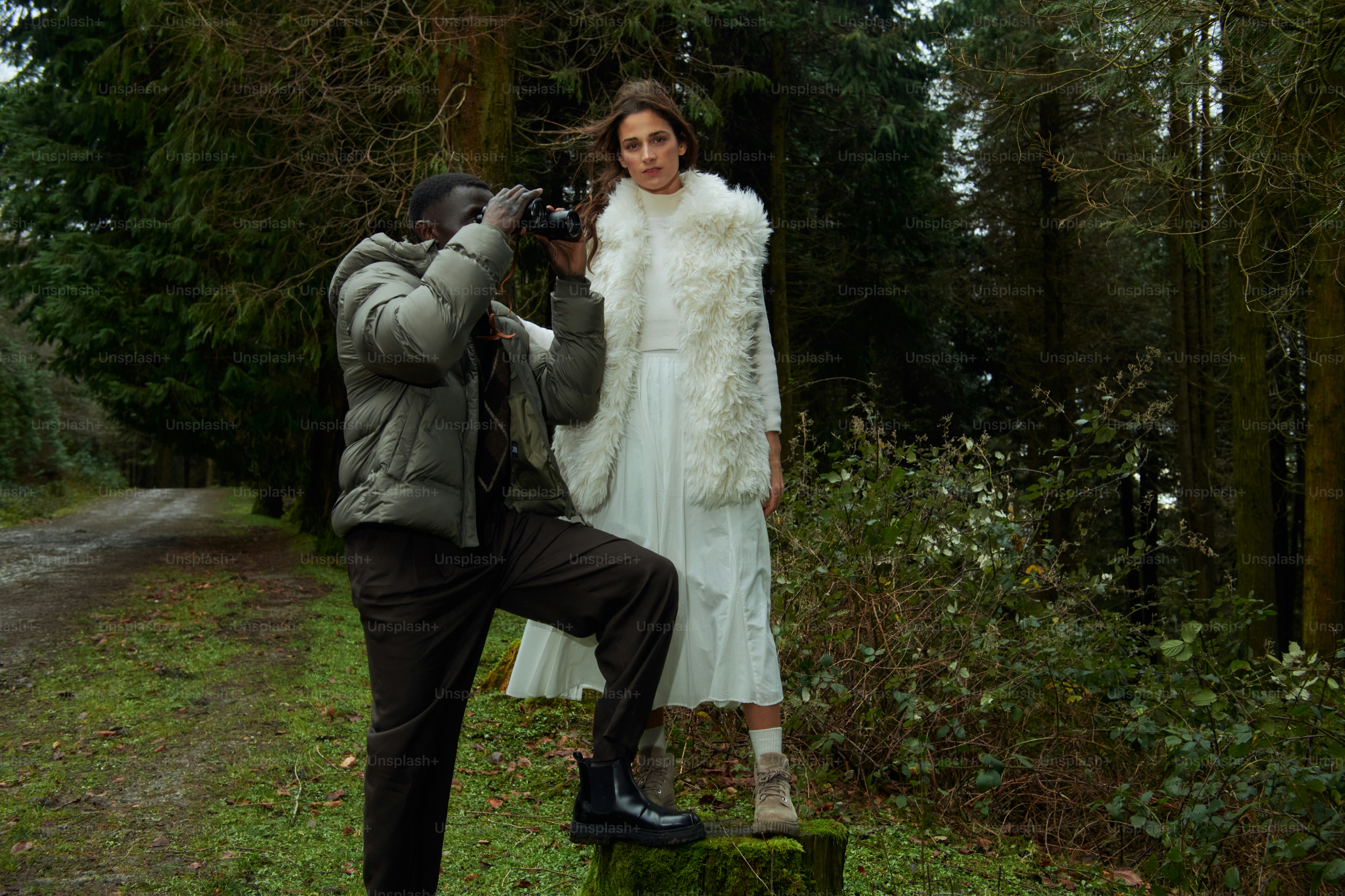 A man taking a picture of a woman in a white dress