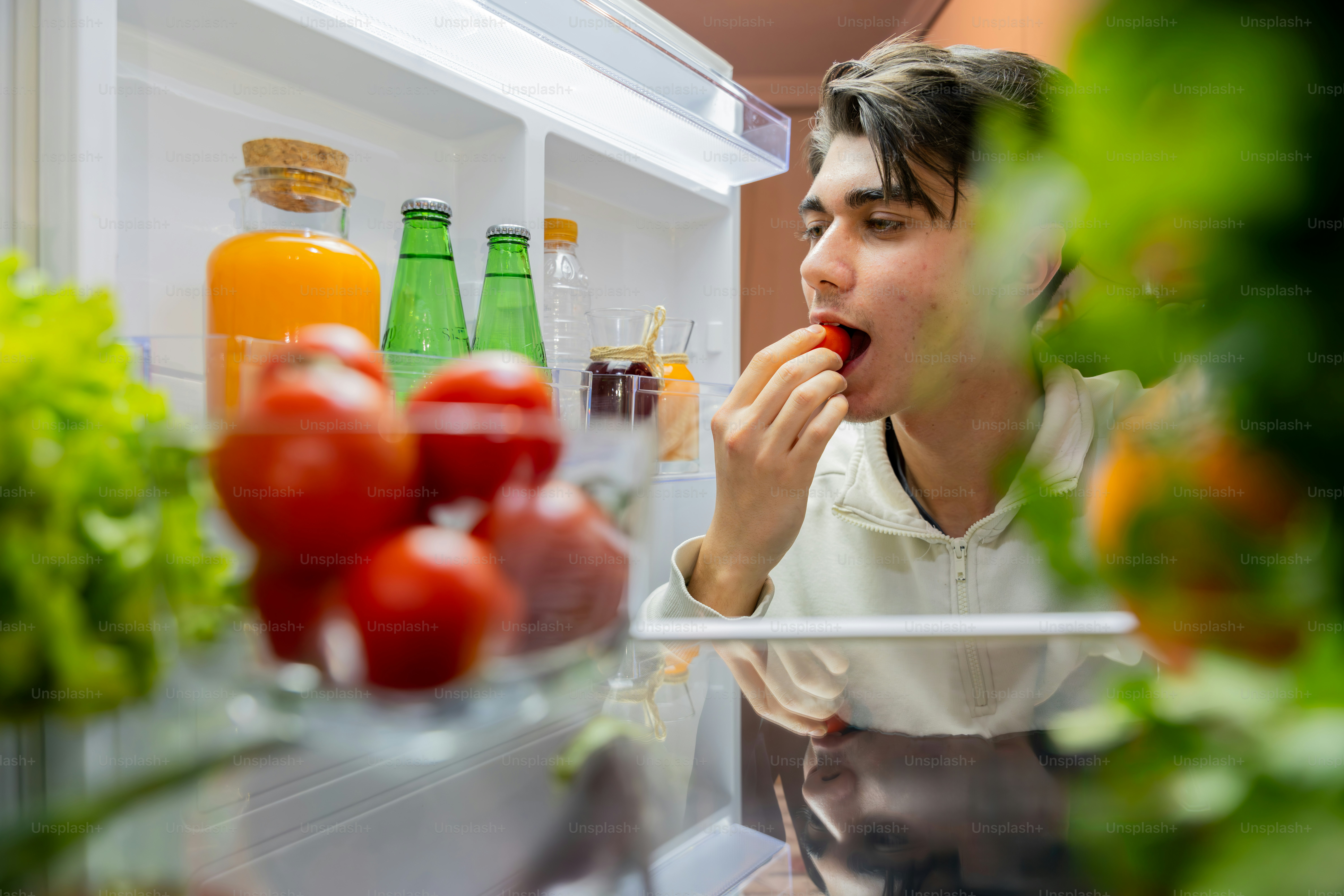 A young man is taking a bite of his food