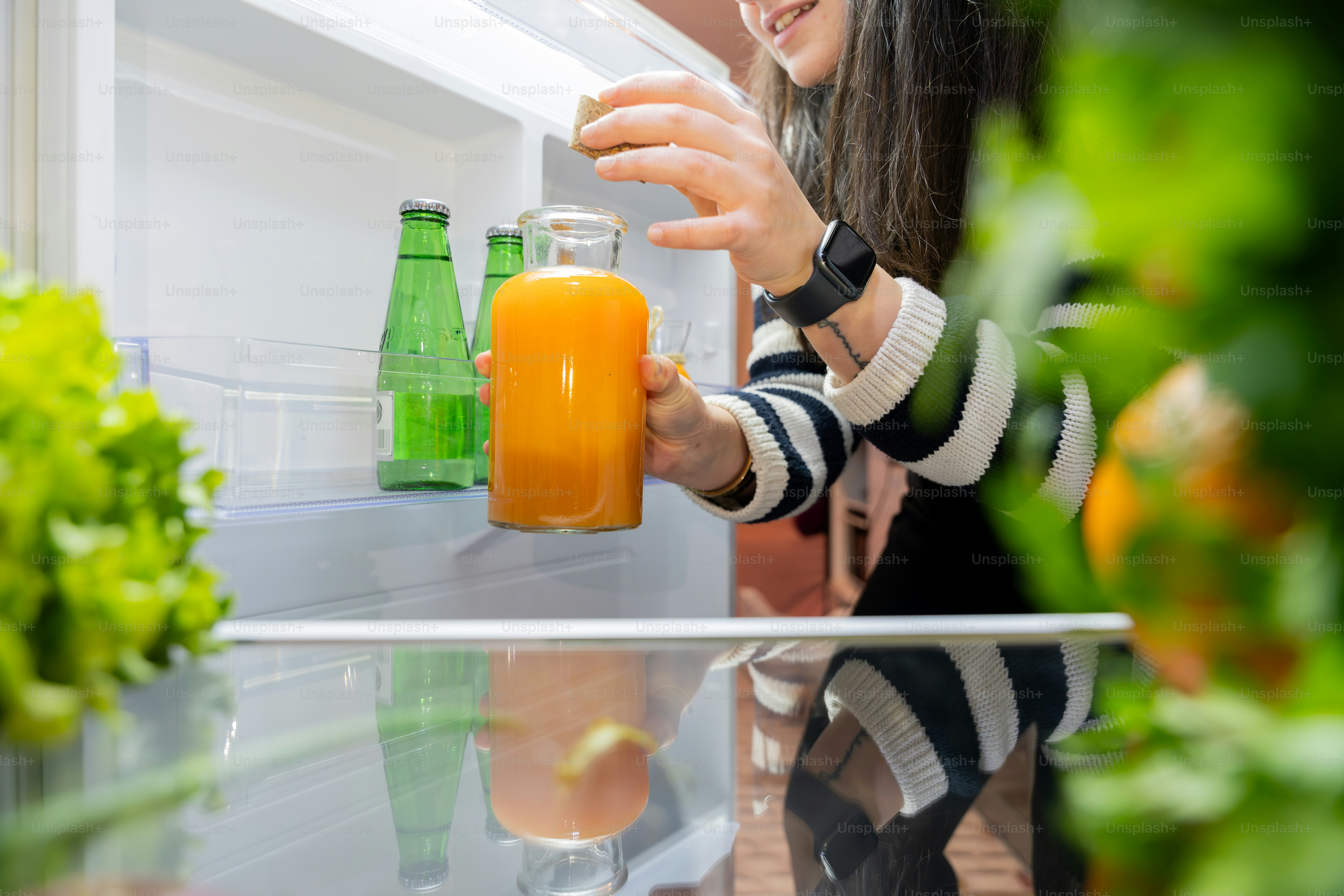Eine Frau hält ein Glas Orangensaft in der Hand