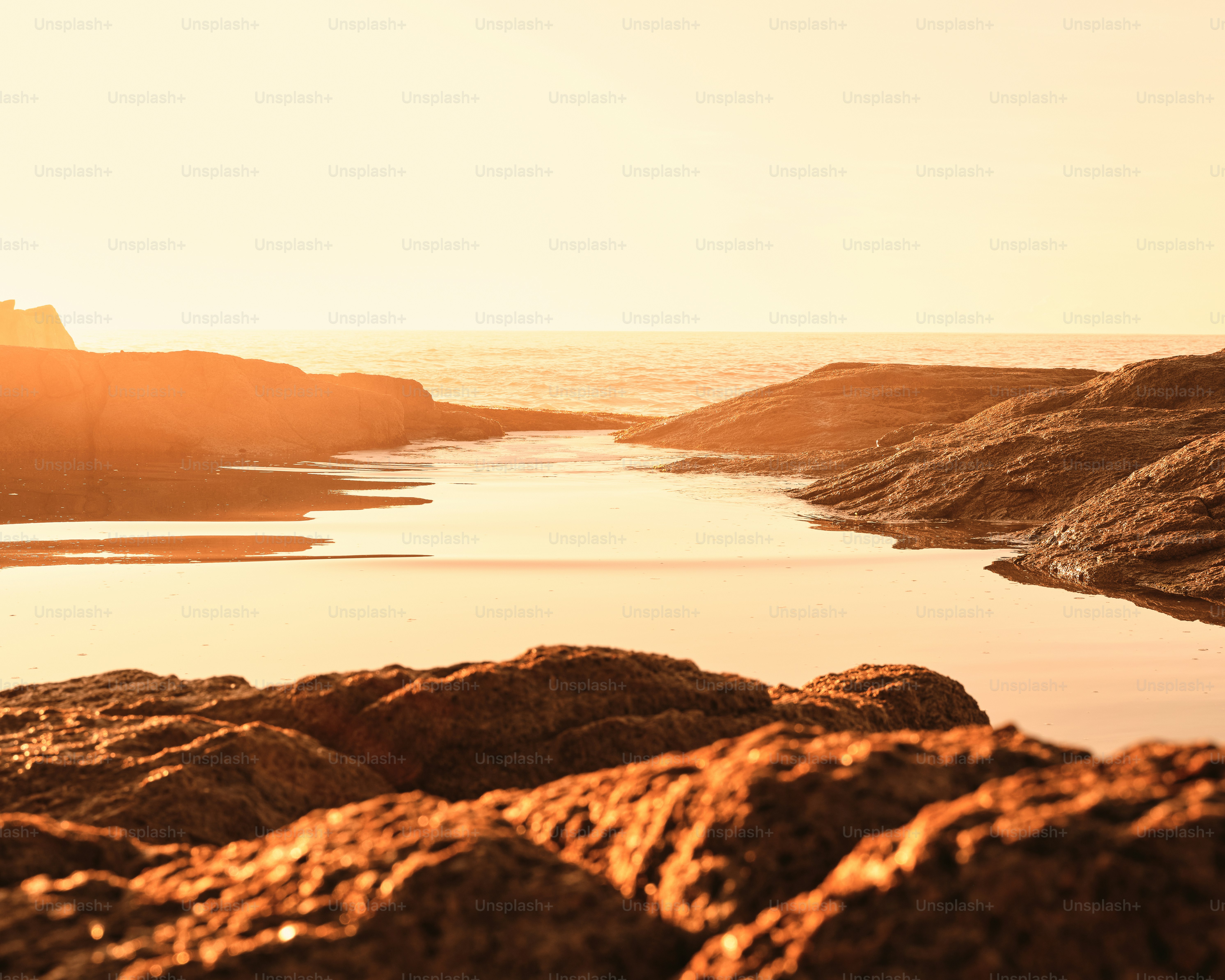 Uma pessoa em pé em uma praia rochosa ao lado do oceano