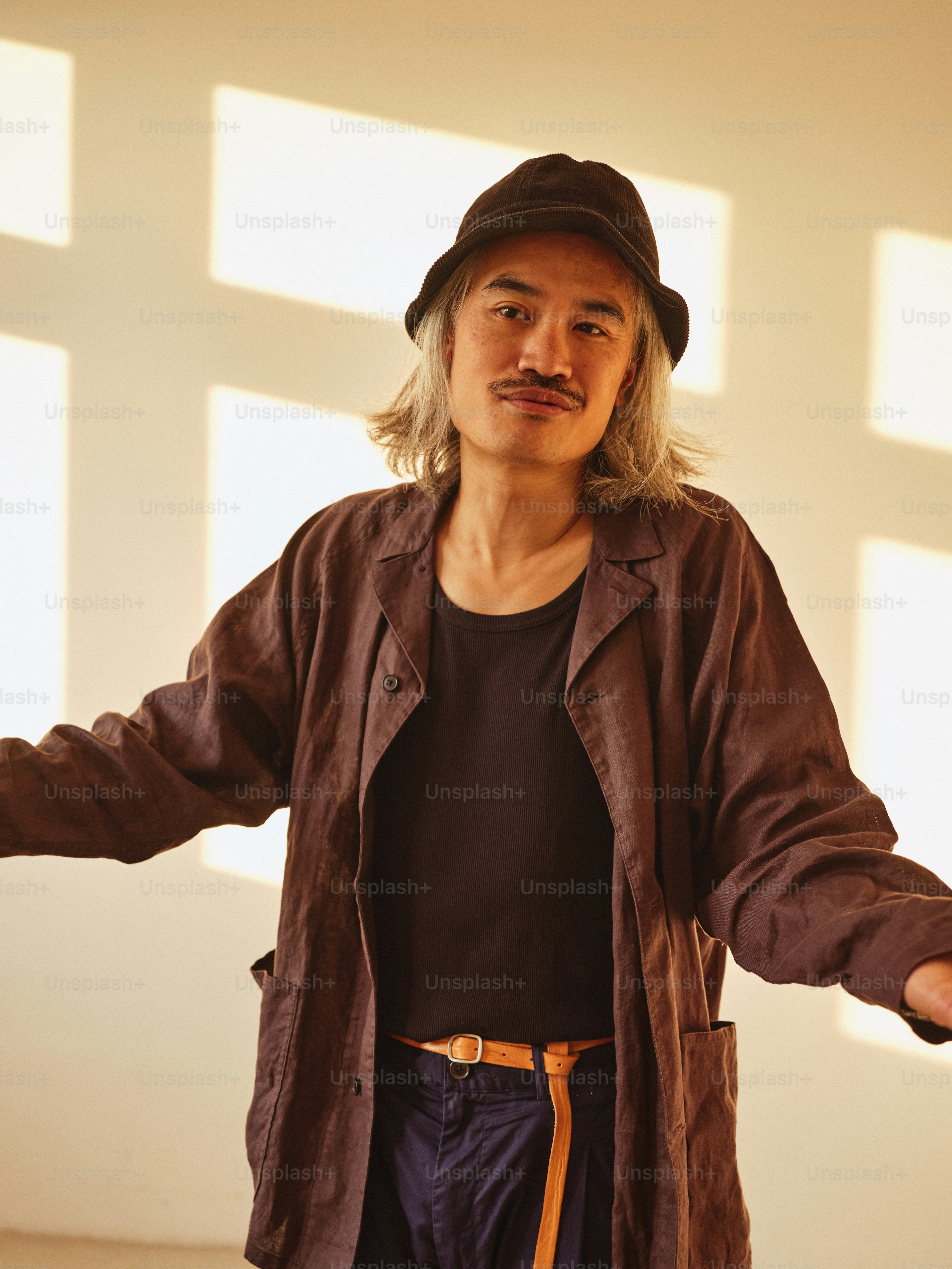 Un hombre con una chaqueta marrón y un sombrero negro