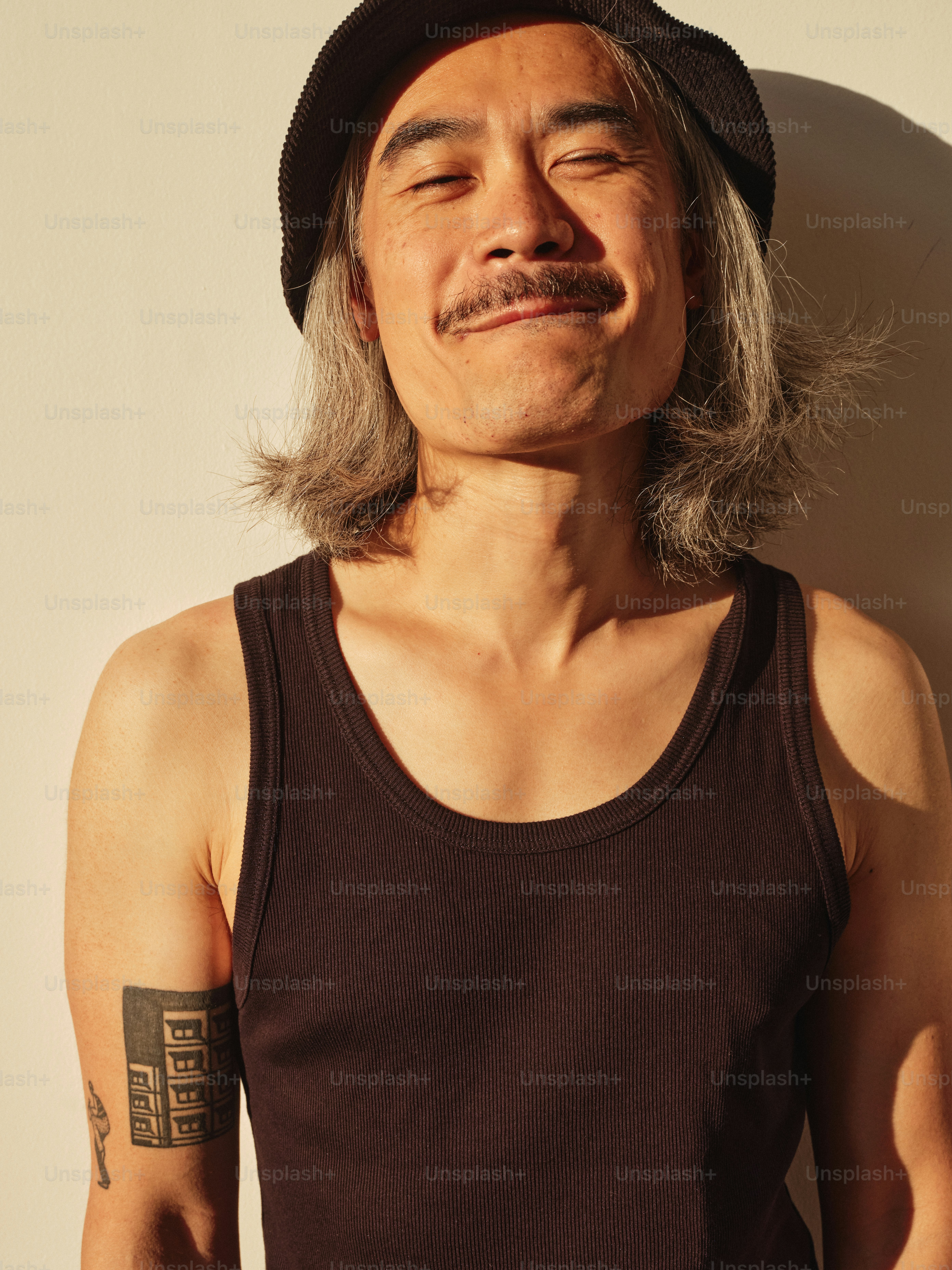 Um homem com cabelo grisalho usando um chapéu preto