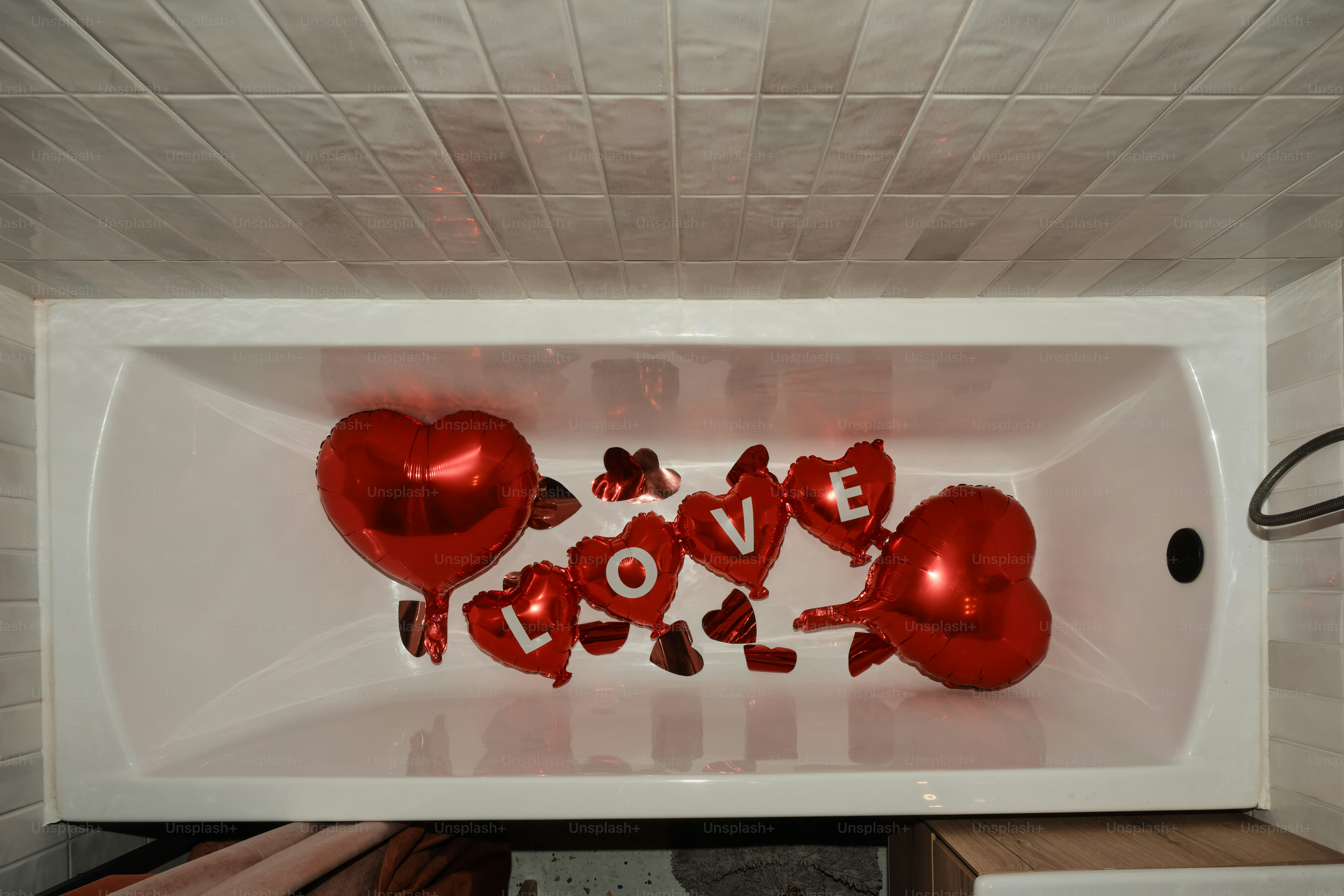 A bathtub with hearts and the word love spelled in it