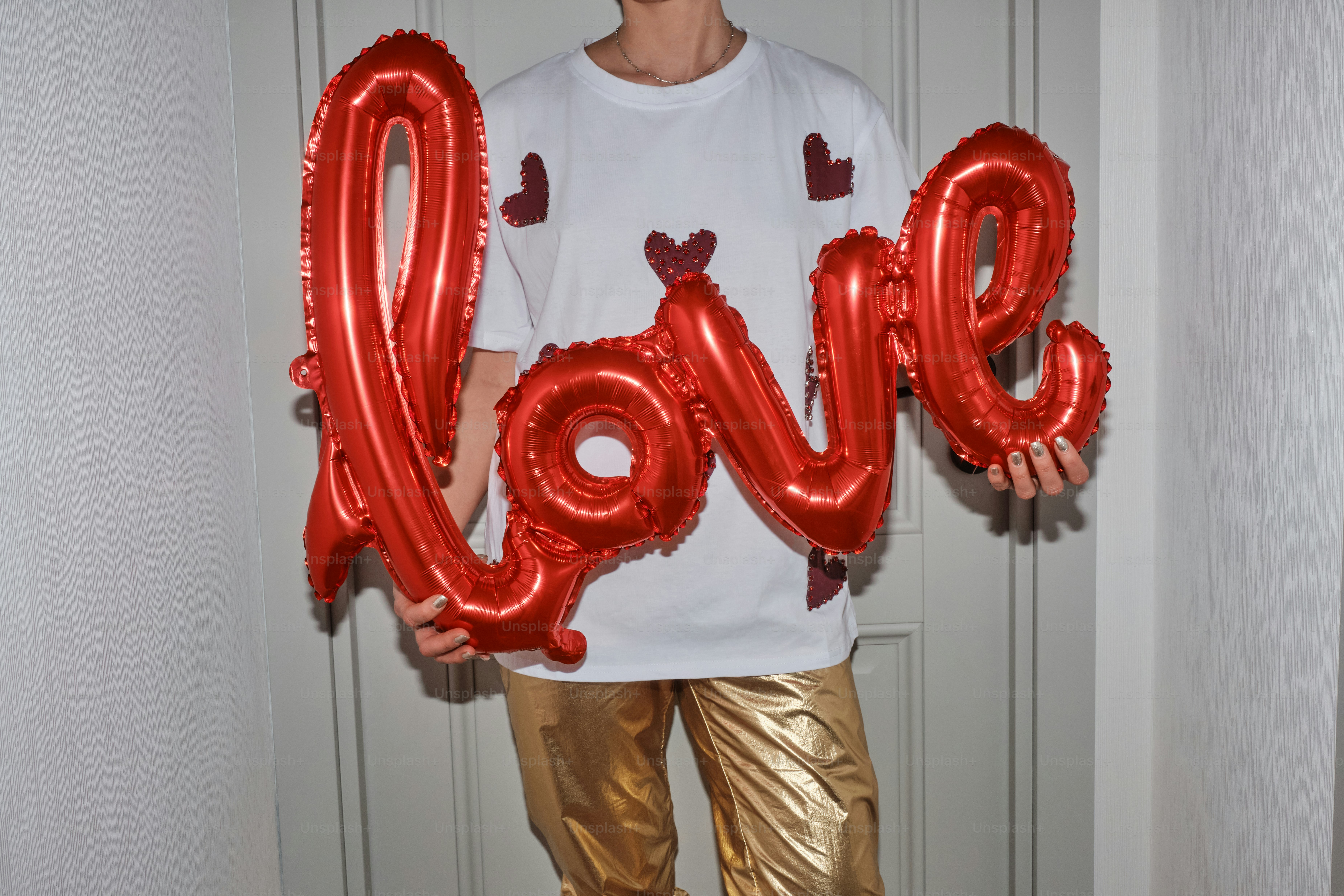 A man holding a red love balloon in his hands
