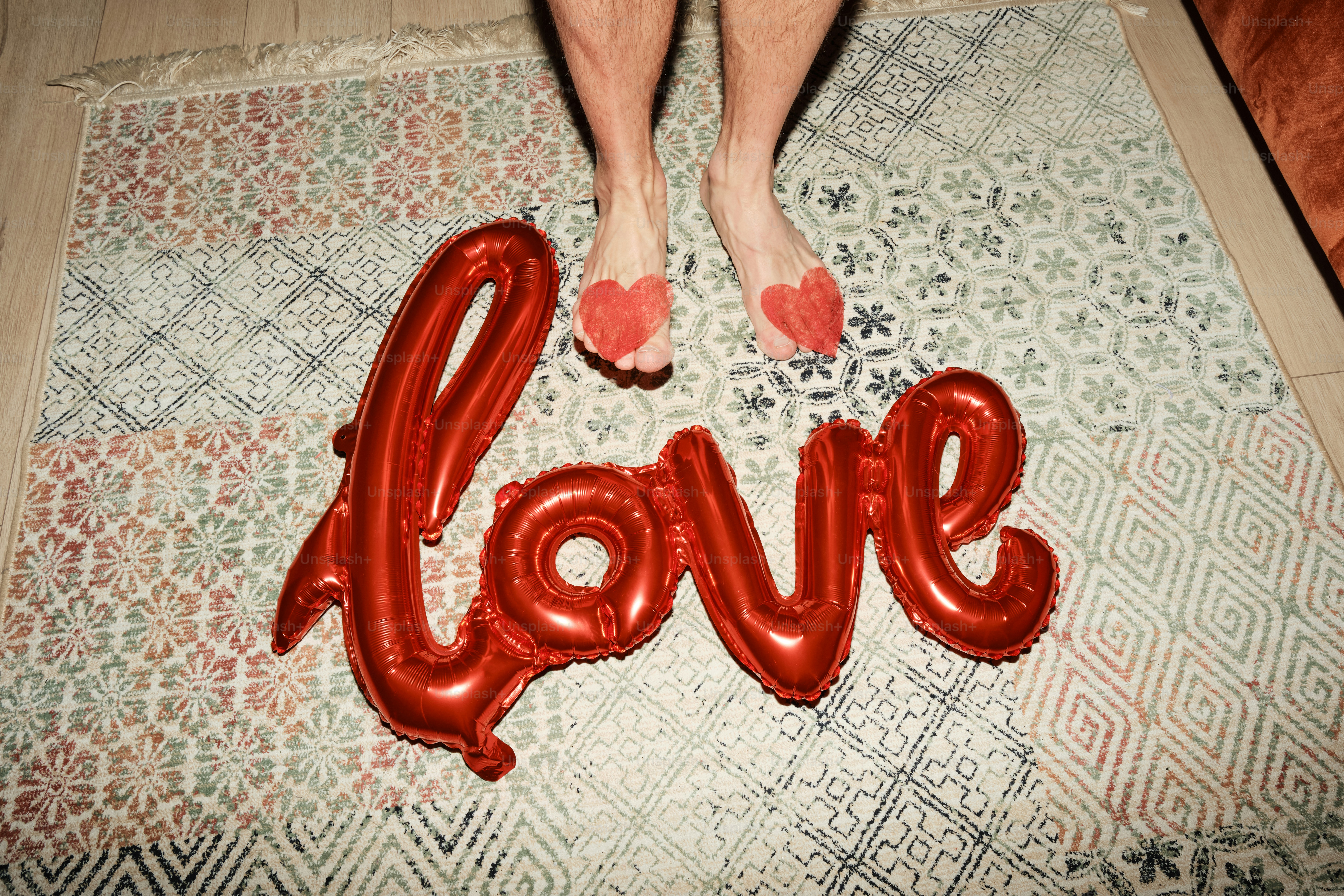 A person standing on a rug with a love balloon