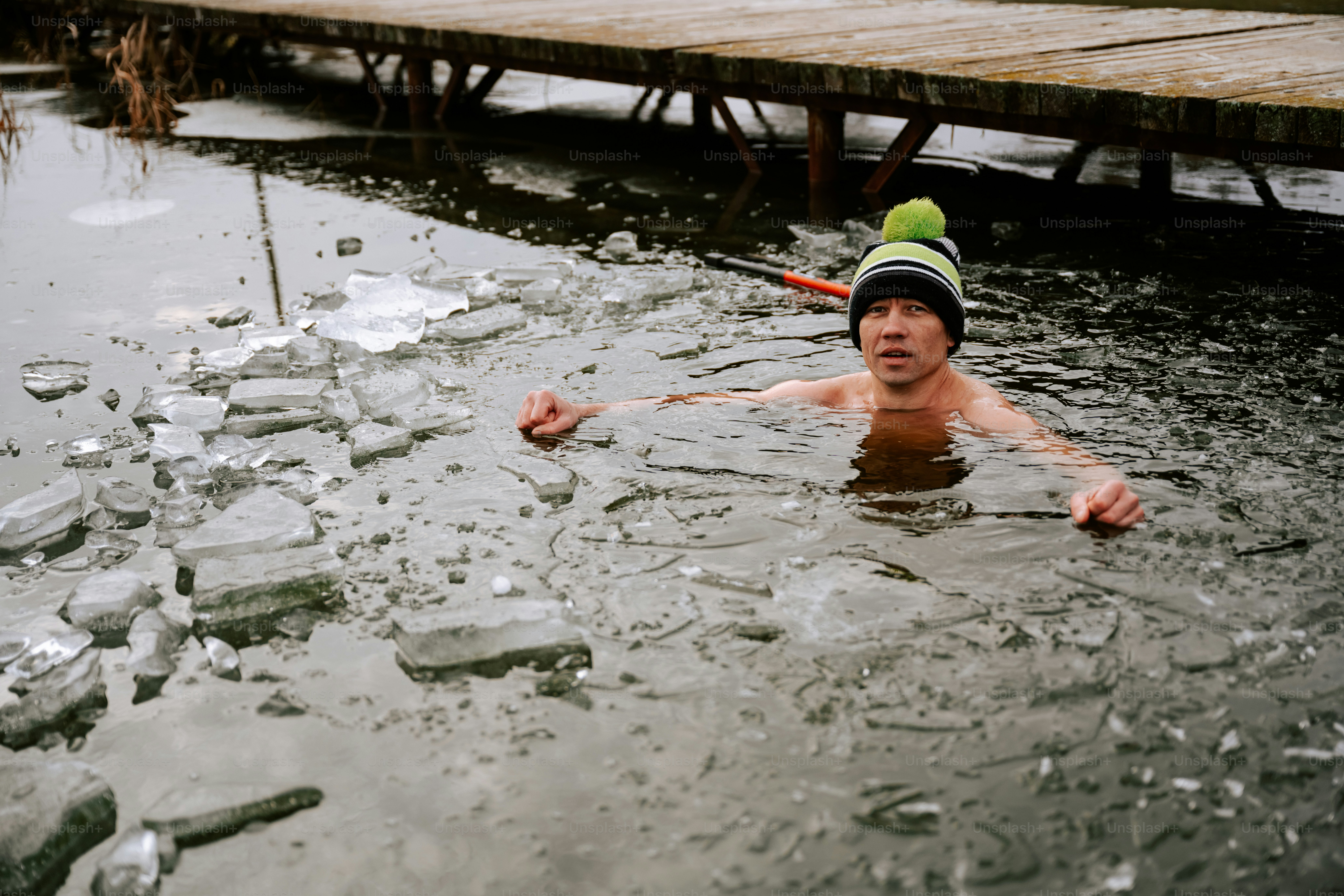 A man in the water with a hat on