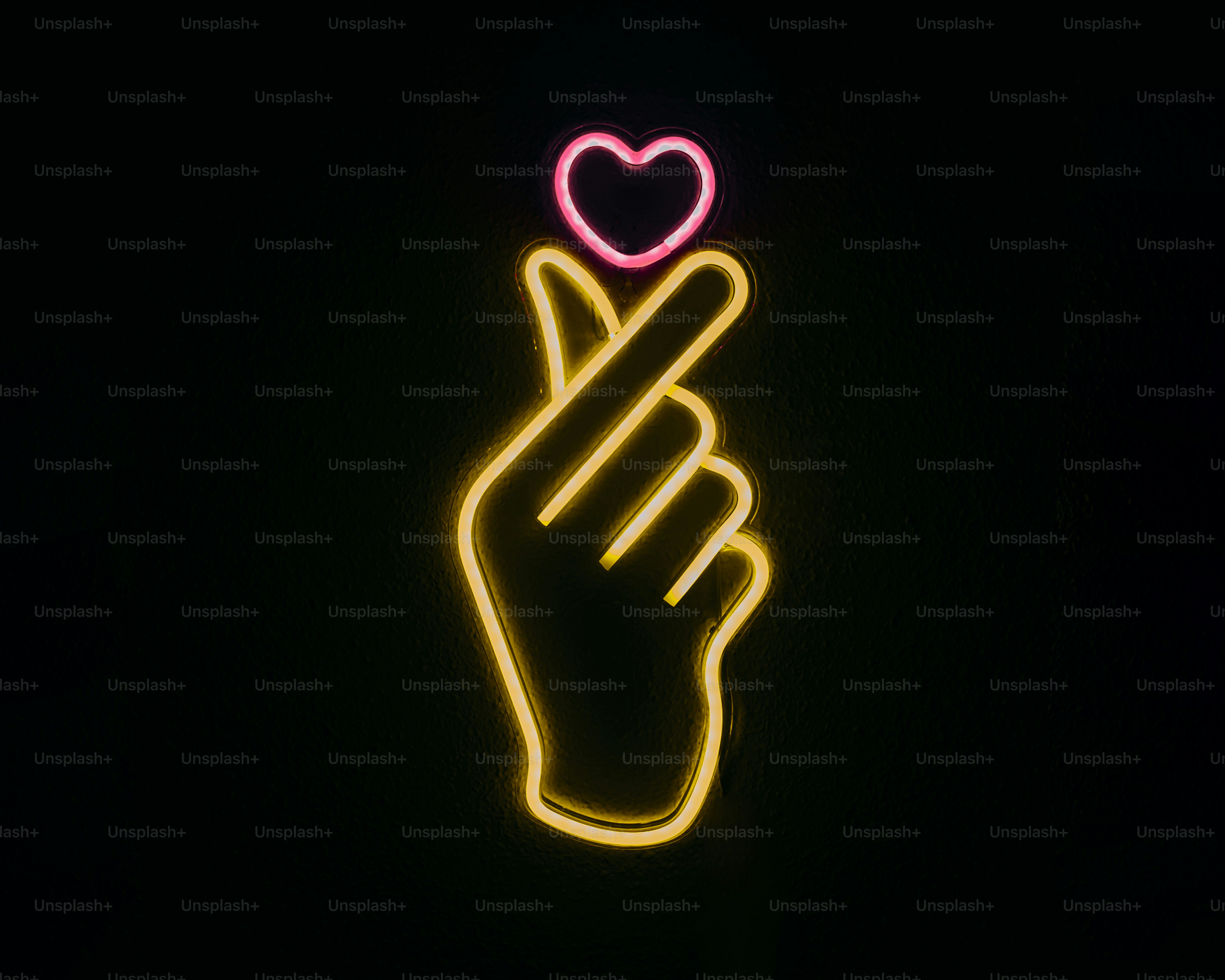 A neon sign with a hand holding a heart