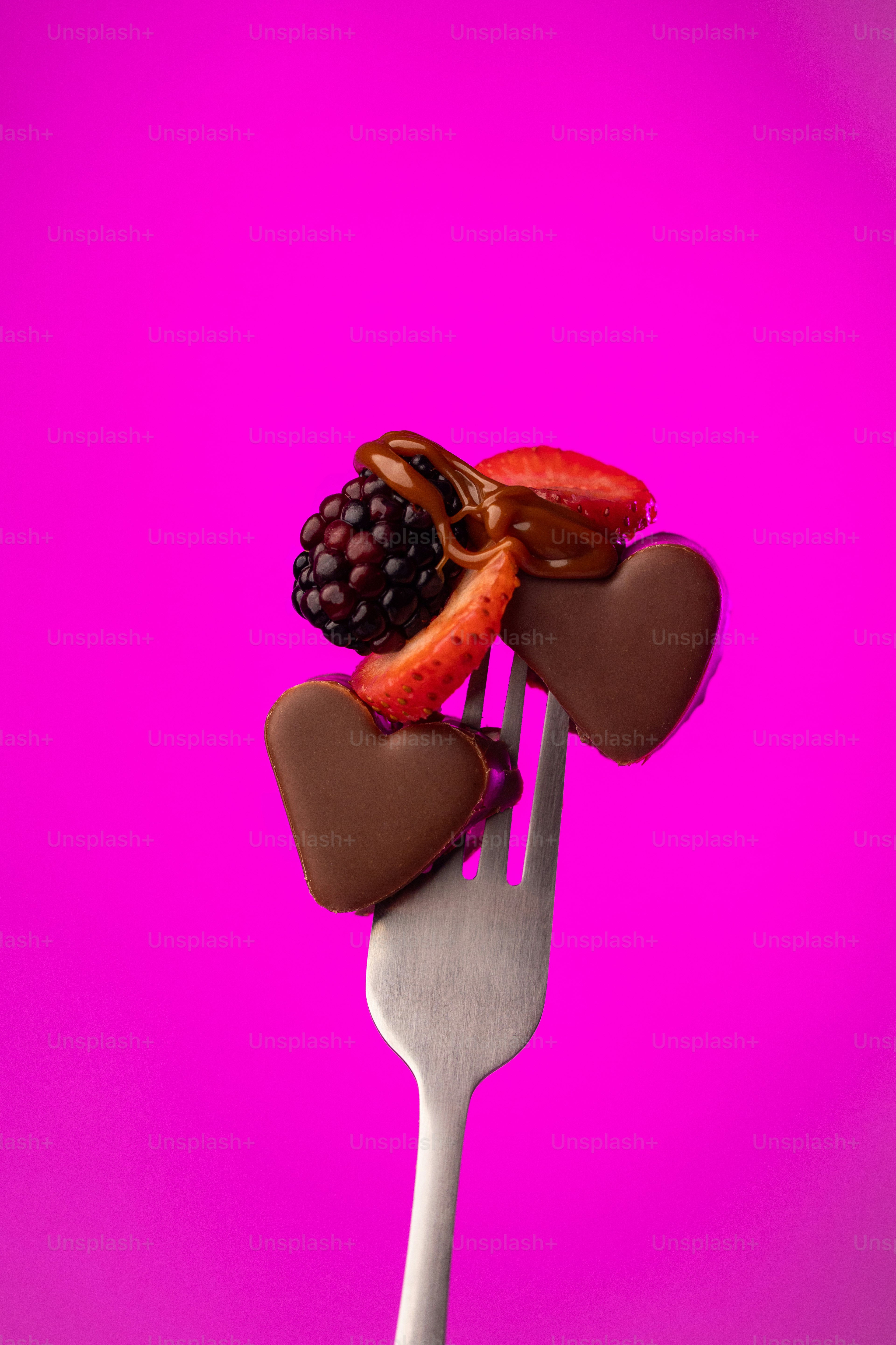 A fork with chocolate hearts and berries on it