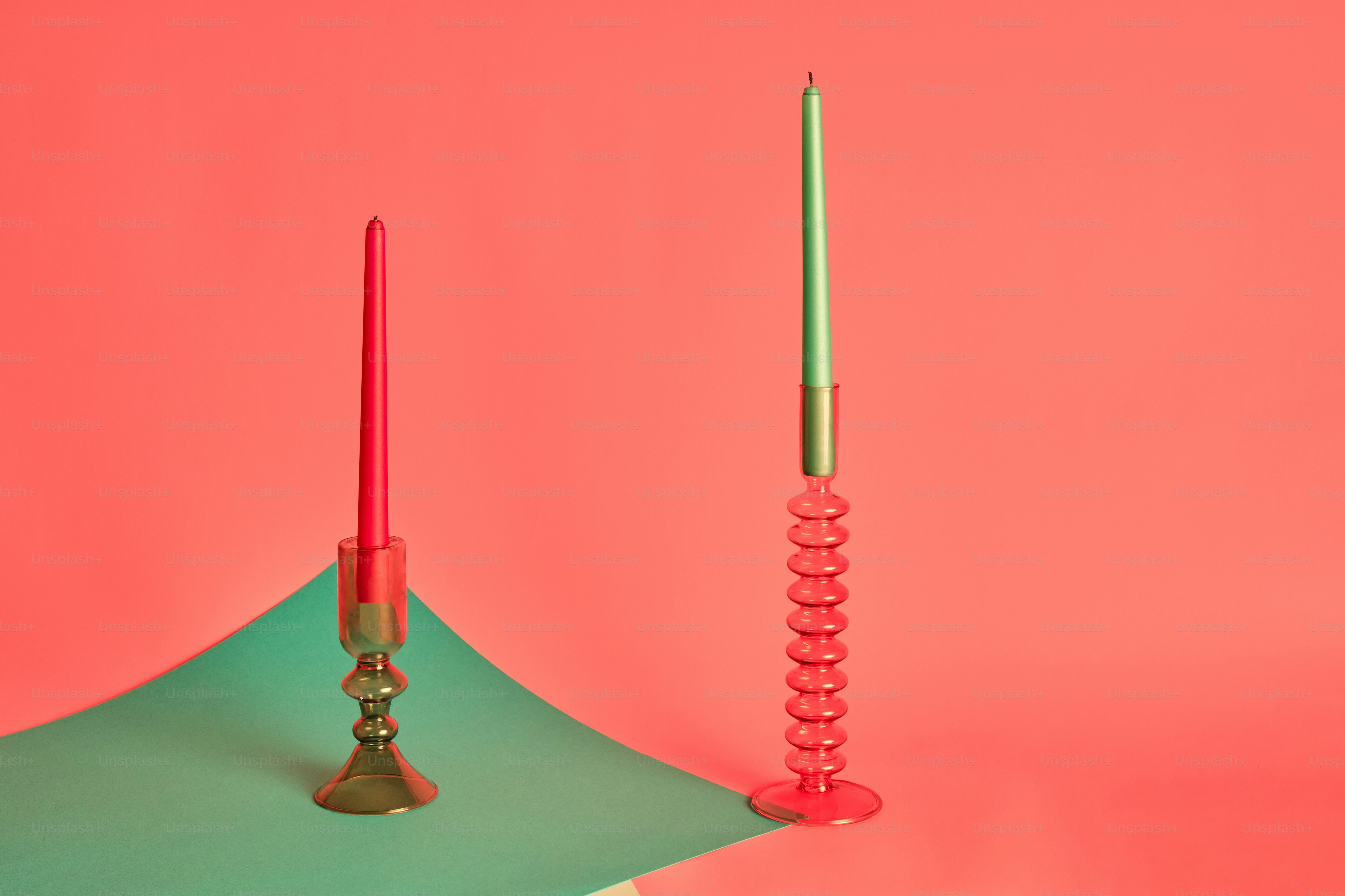 Ein Paar rote Kerzen, die auf einem grünen Regenschirm sitzen