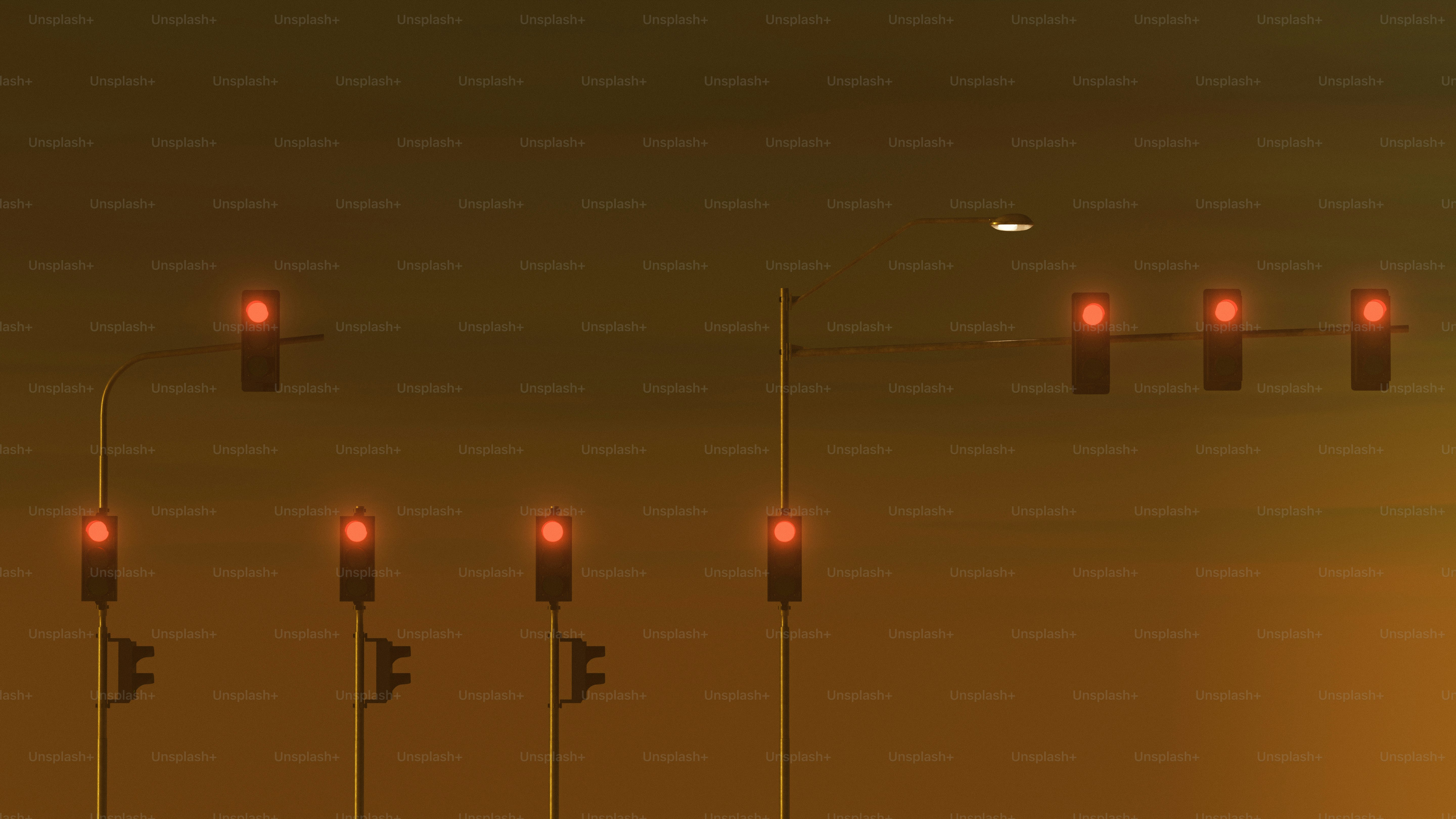 A group of traffic lights with a plane in the background