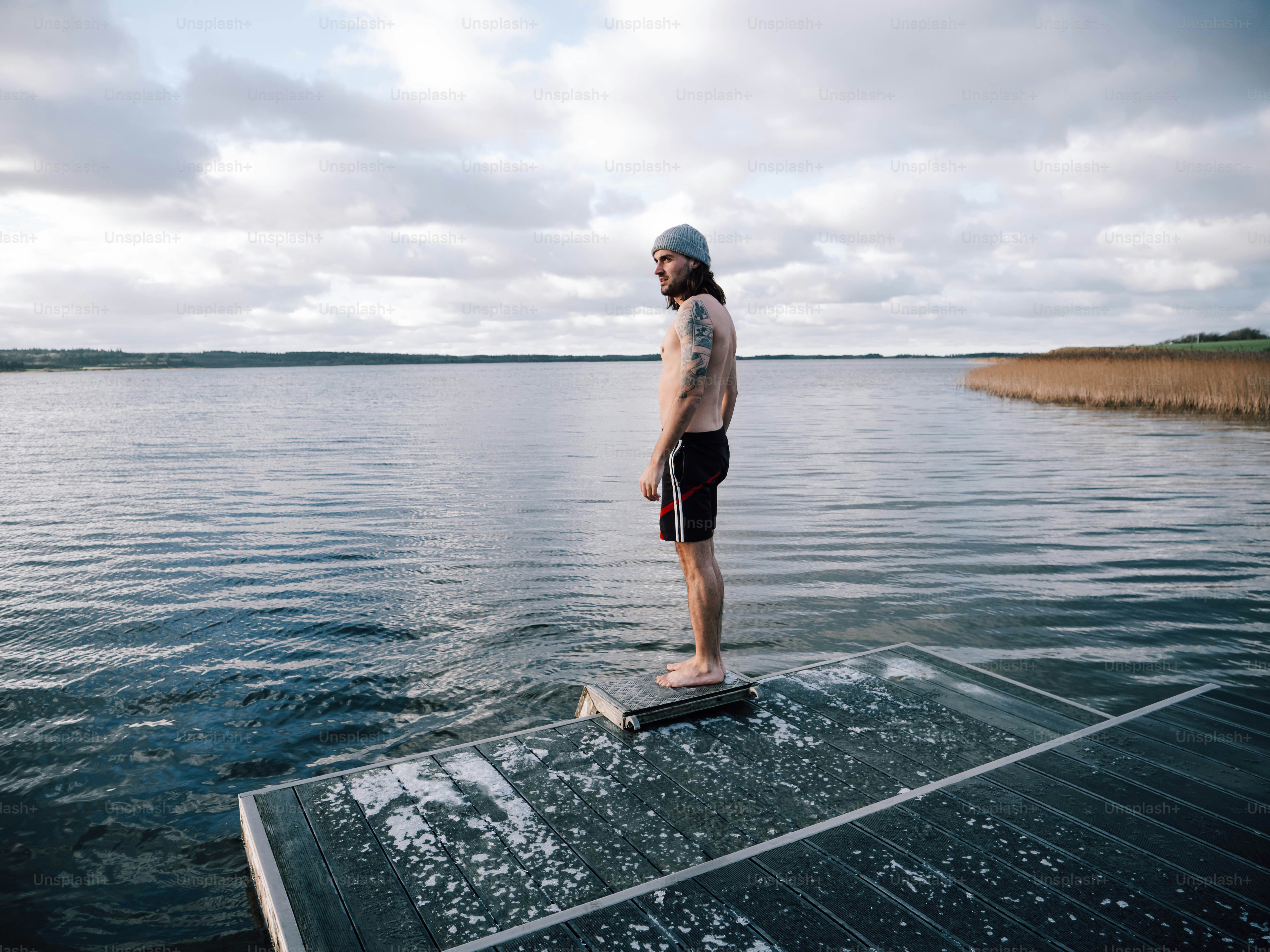 A man standing on a boat in the water photo – Winter Image on Unsplash