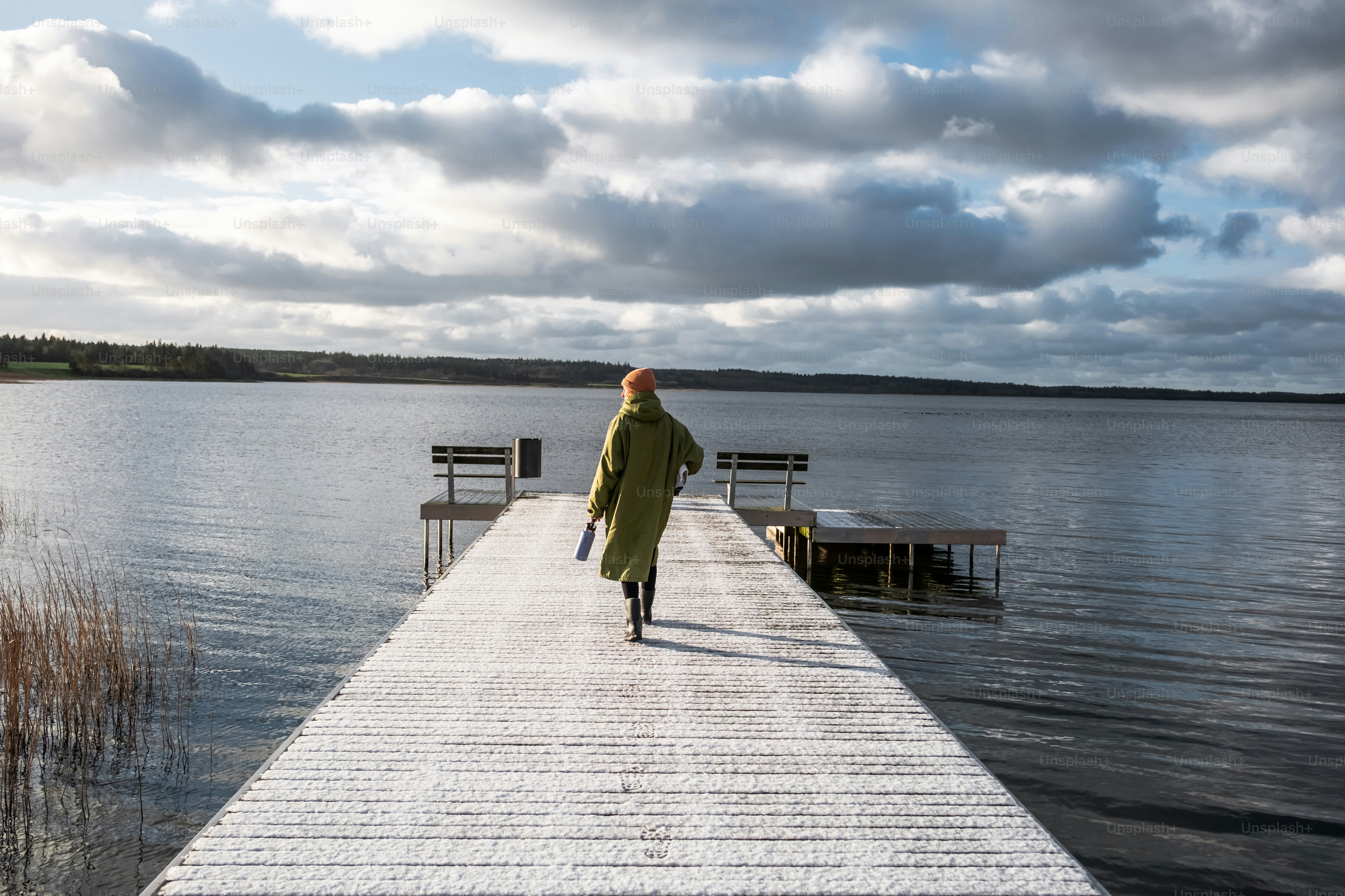 A person walking down a dock towards a body of water