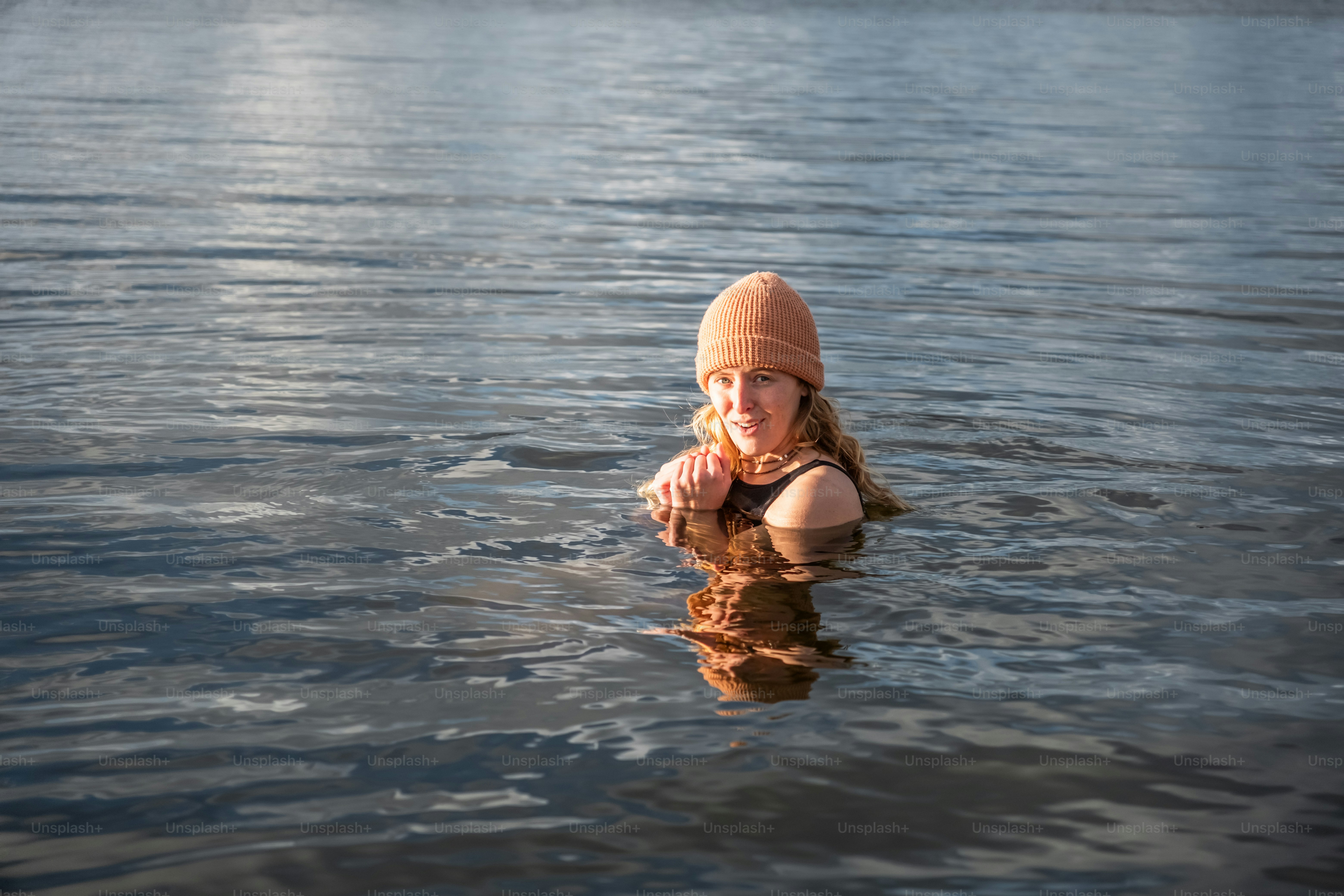 A woman in a beanie is in the water