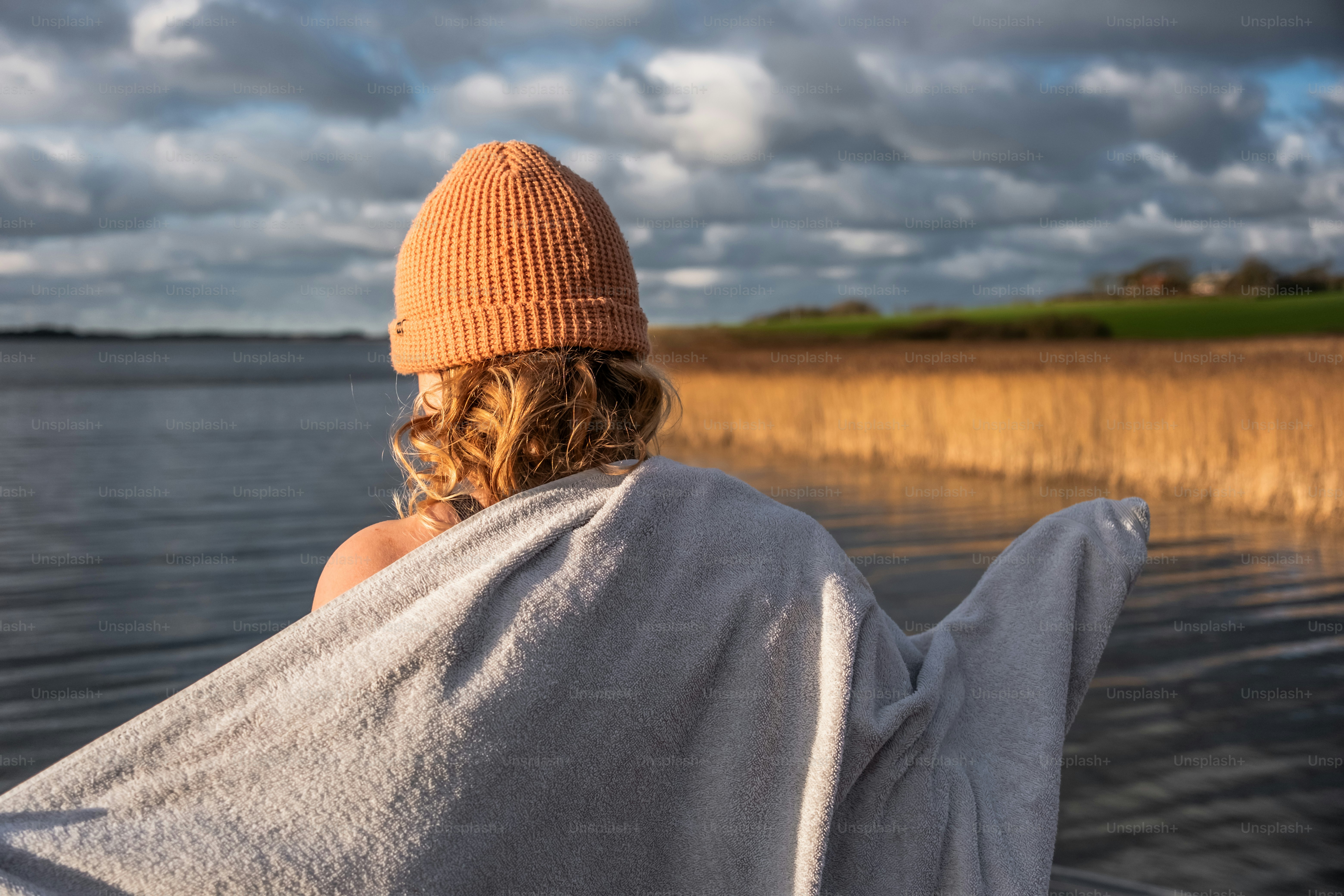 A woman wrapped in a towel sitting in the water