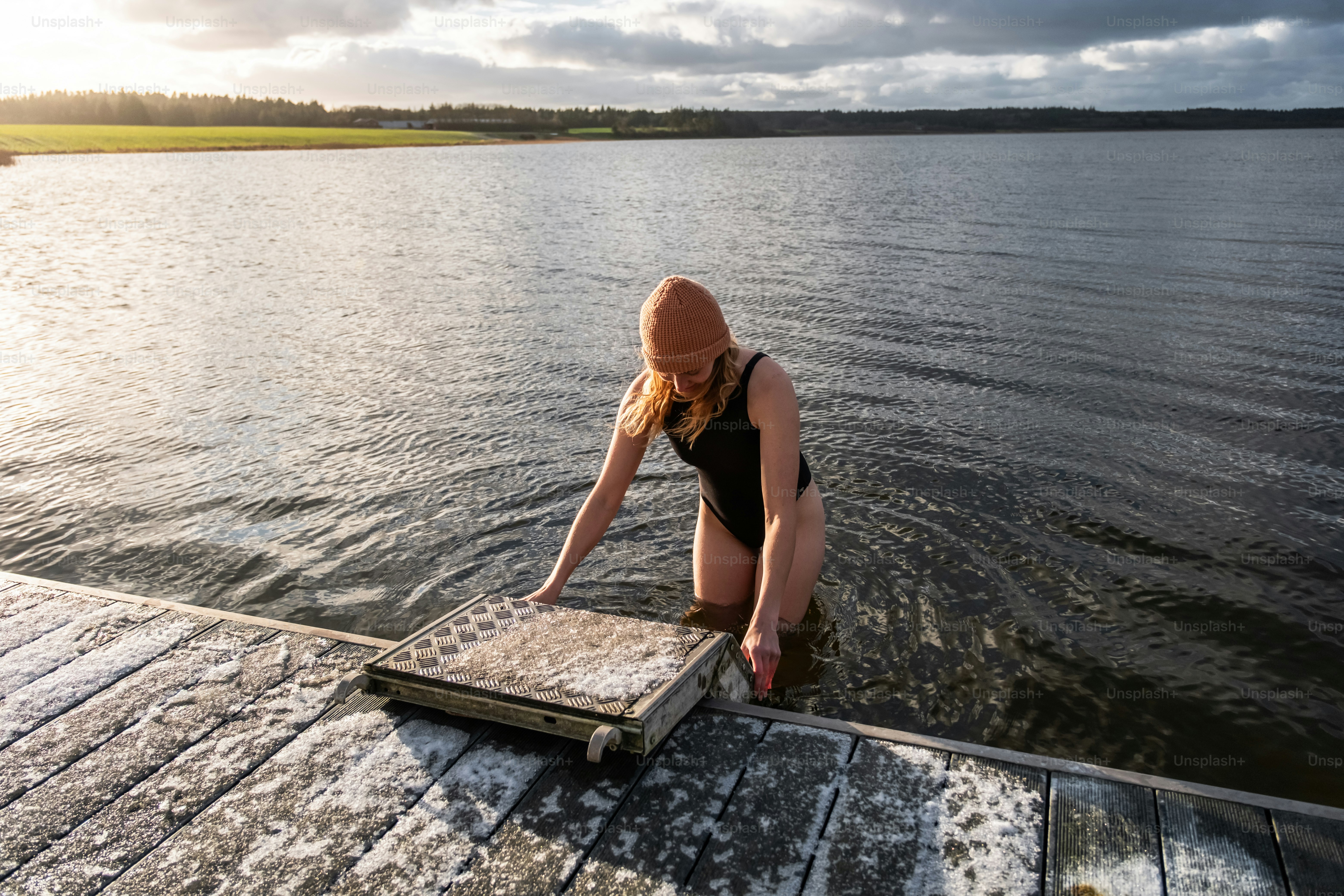 A woman in a bathing suit sitting on a dock