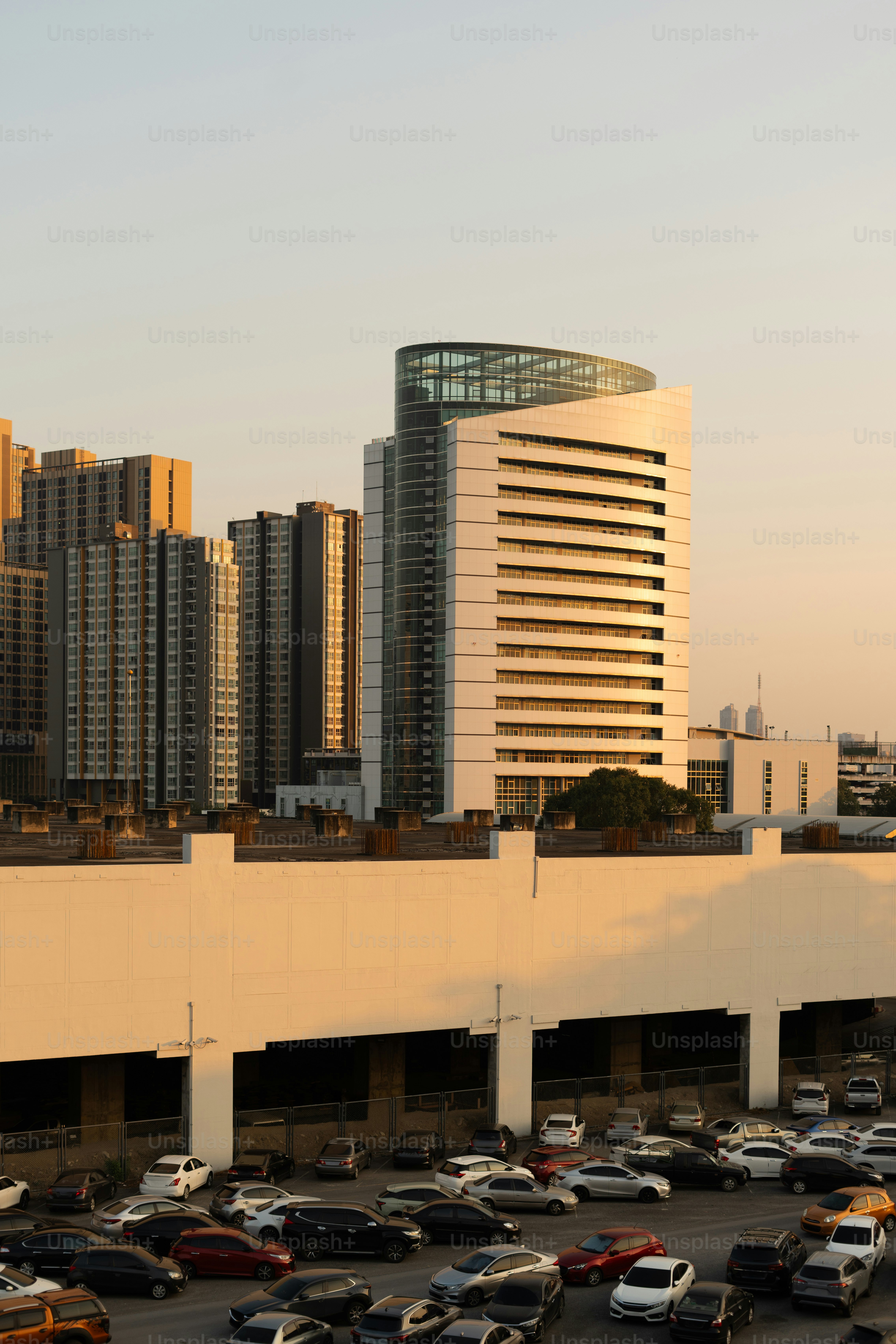 A parking lot full of cars in front of tall buildings