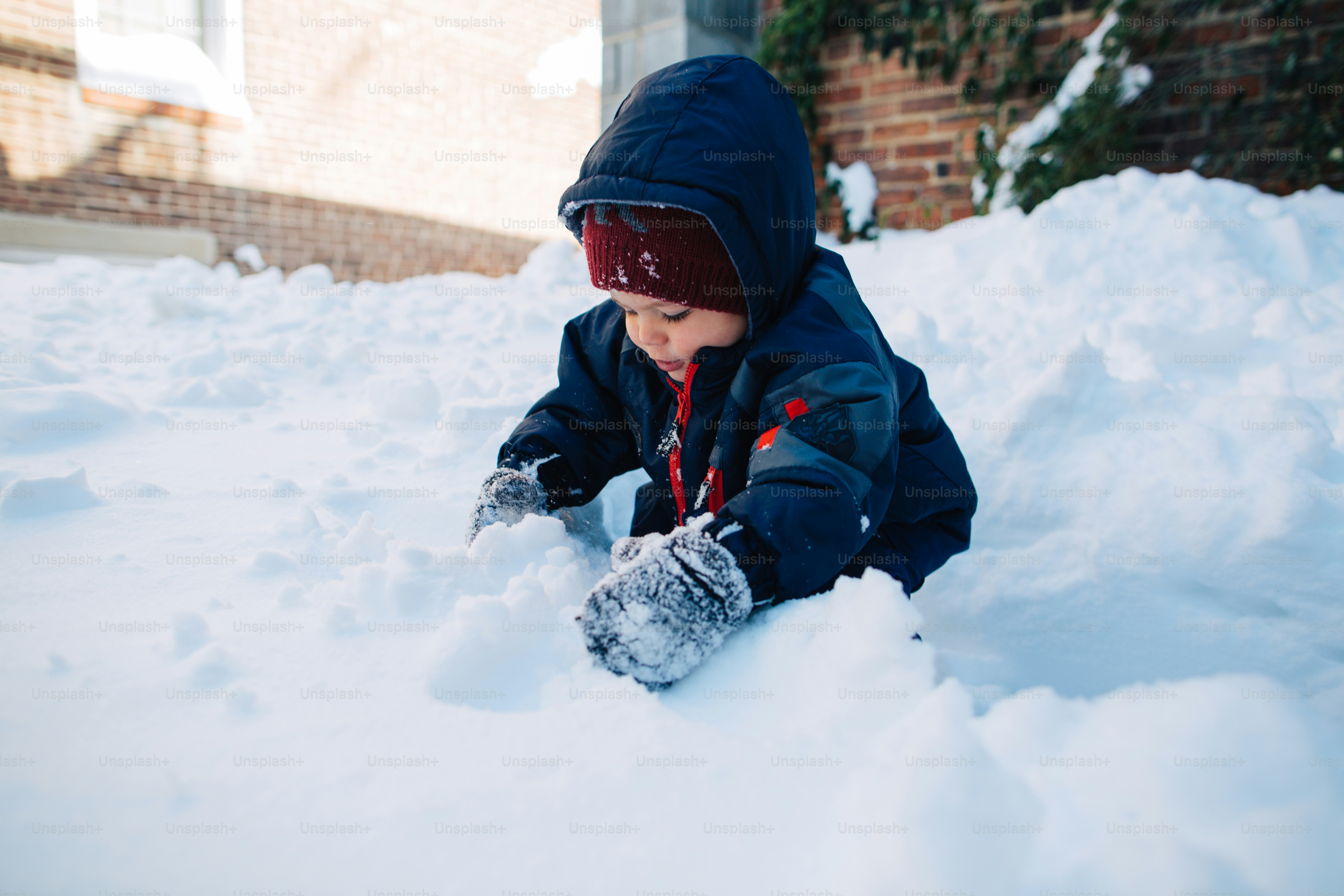 A small child playing in the snow outside