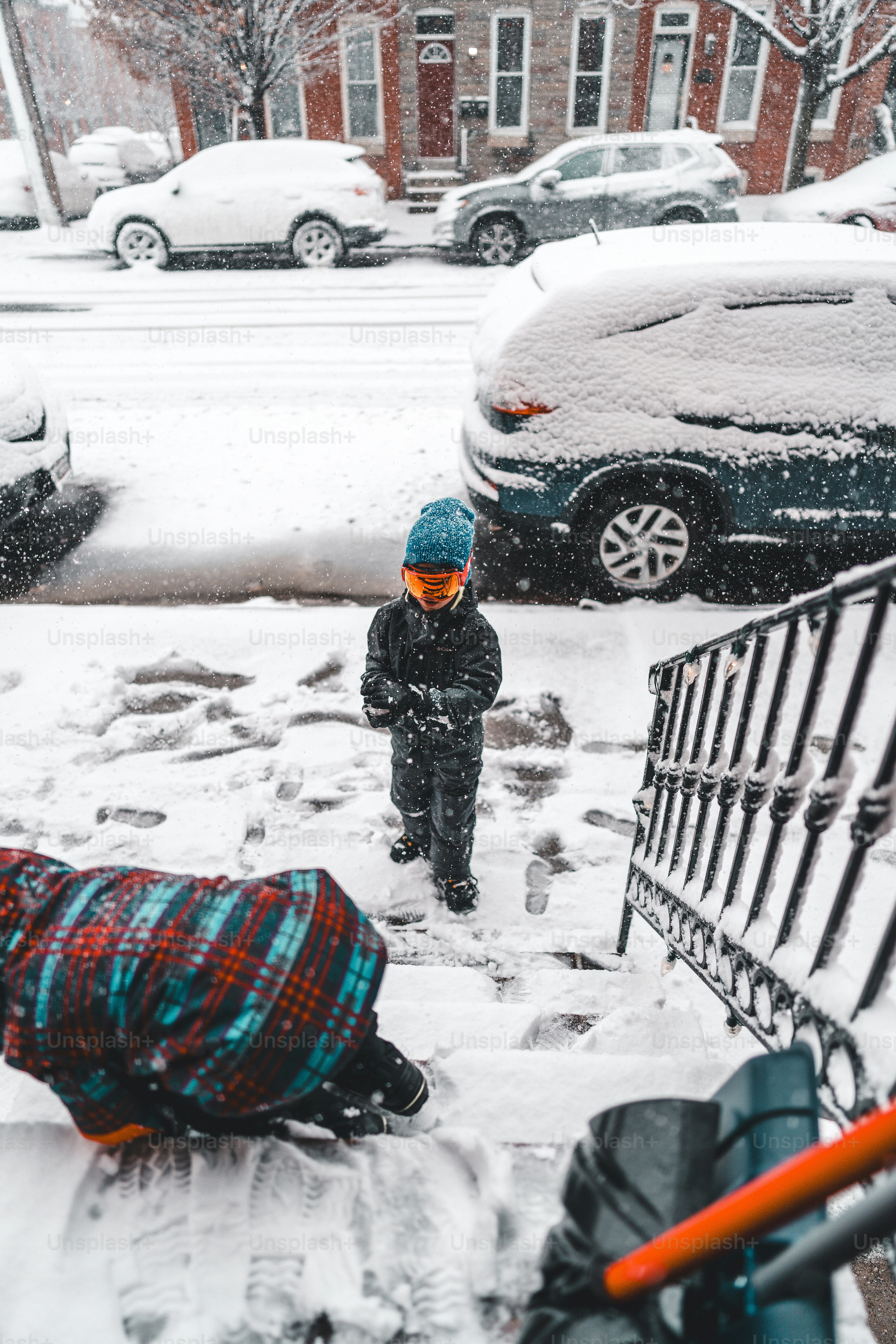 A person standing in the snow next to a shopping cart