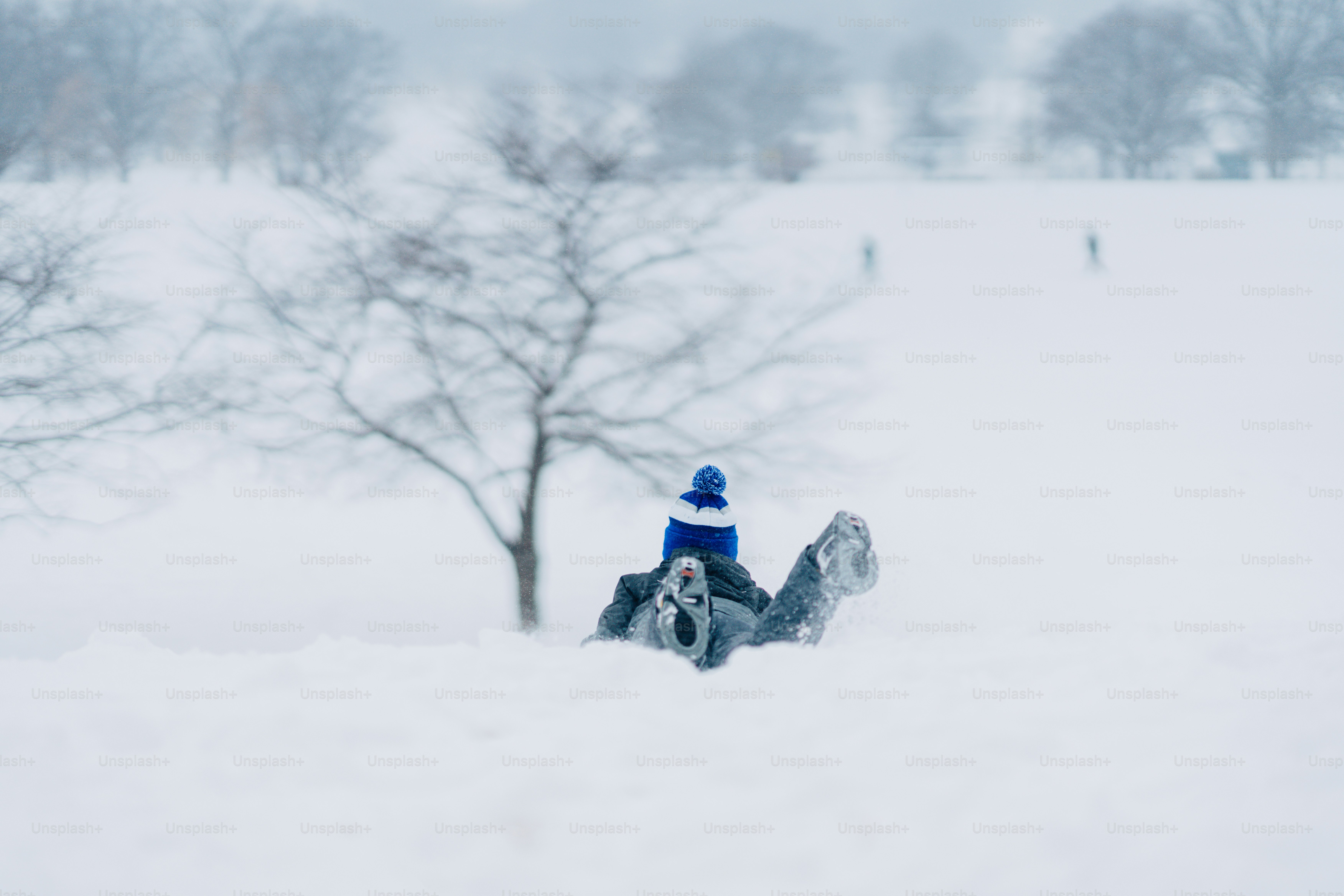 A person sitting in the snow on a snowboard