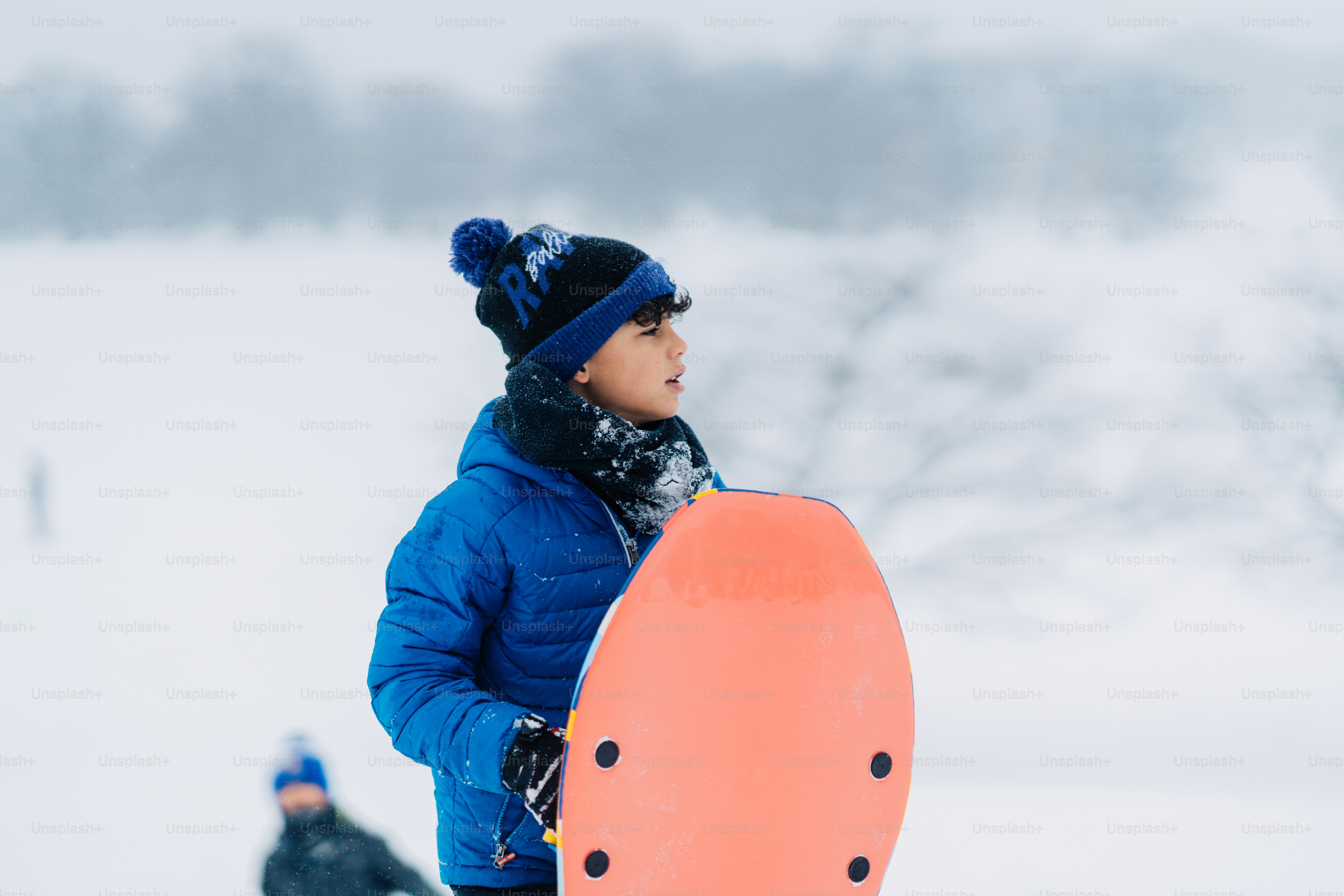 雪の中でスノーボードを持つ男性