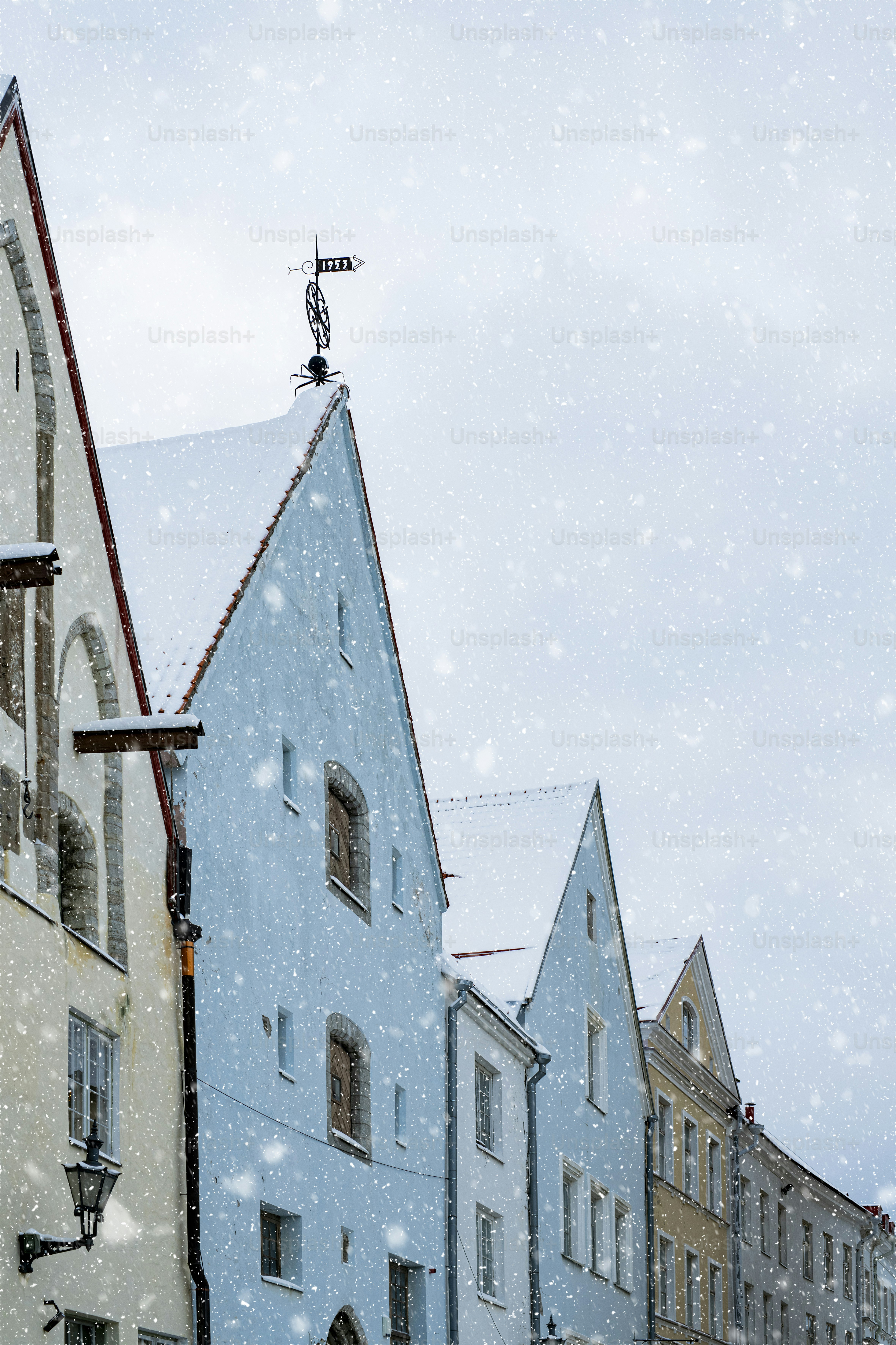 Una strada innevata con edifici e una torre dell'orologio