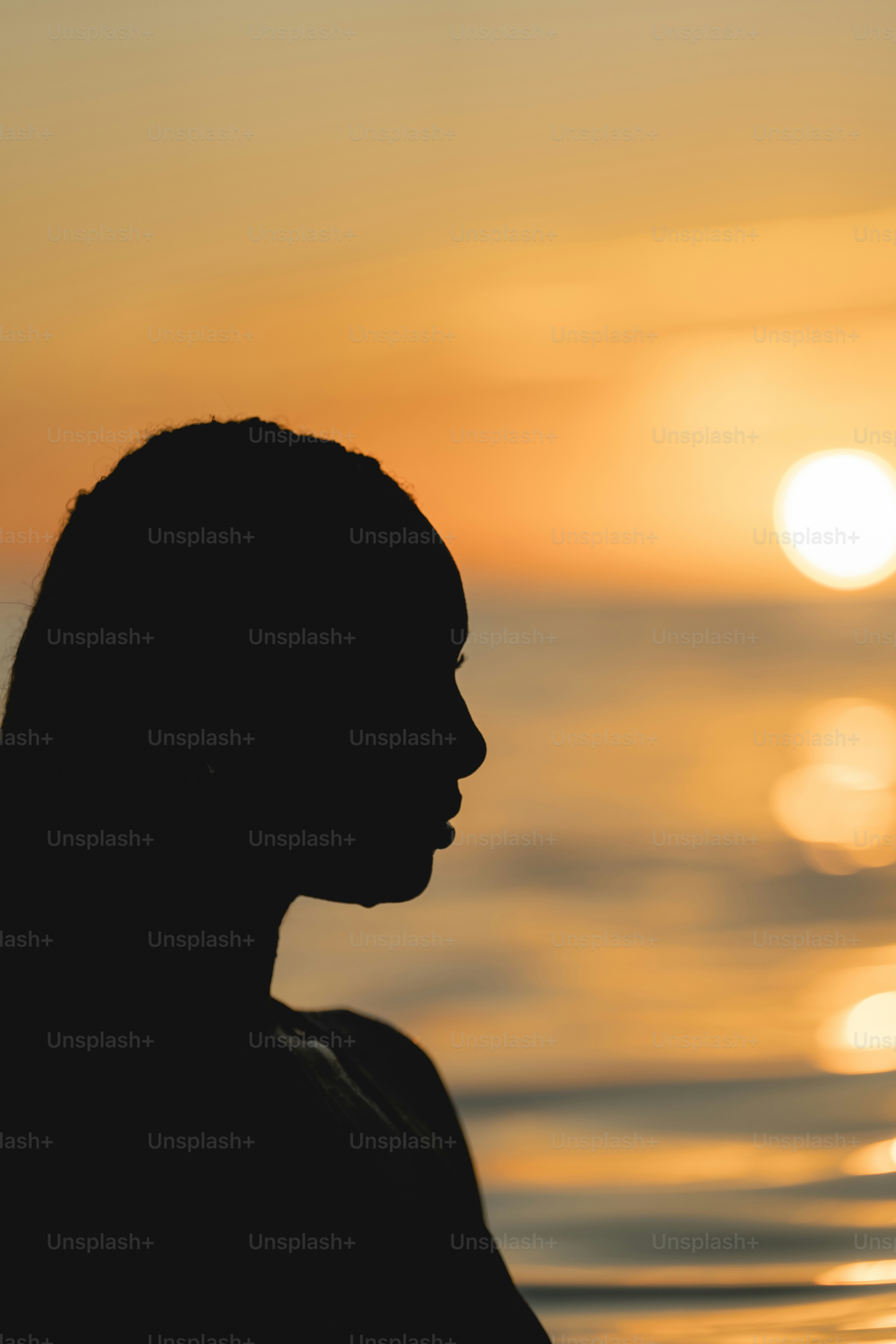 Uma silhueta de uma pessoa em pé na frente de um corpo de água