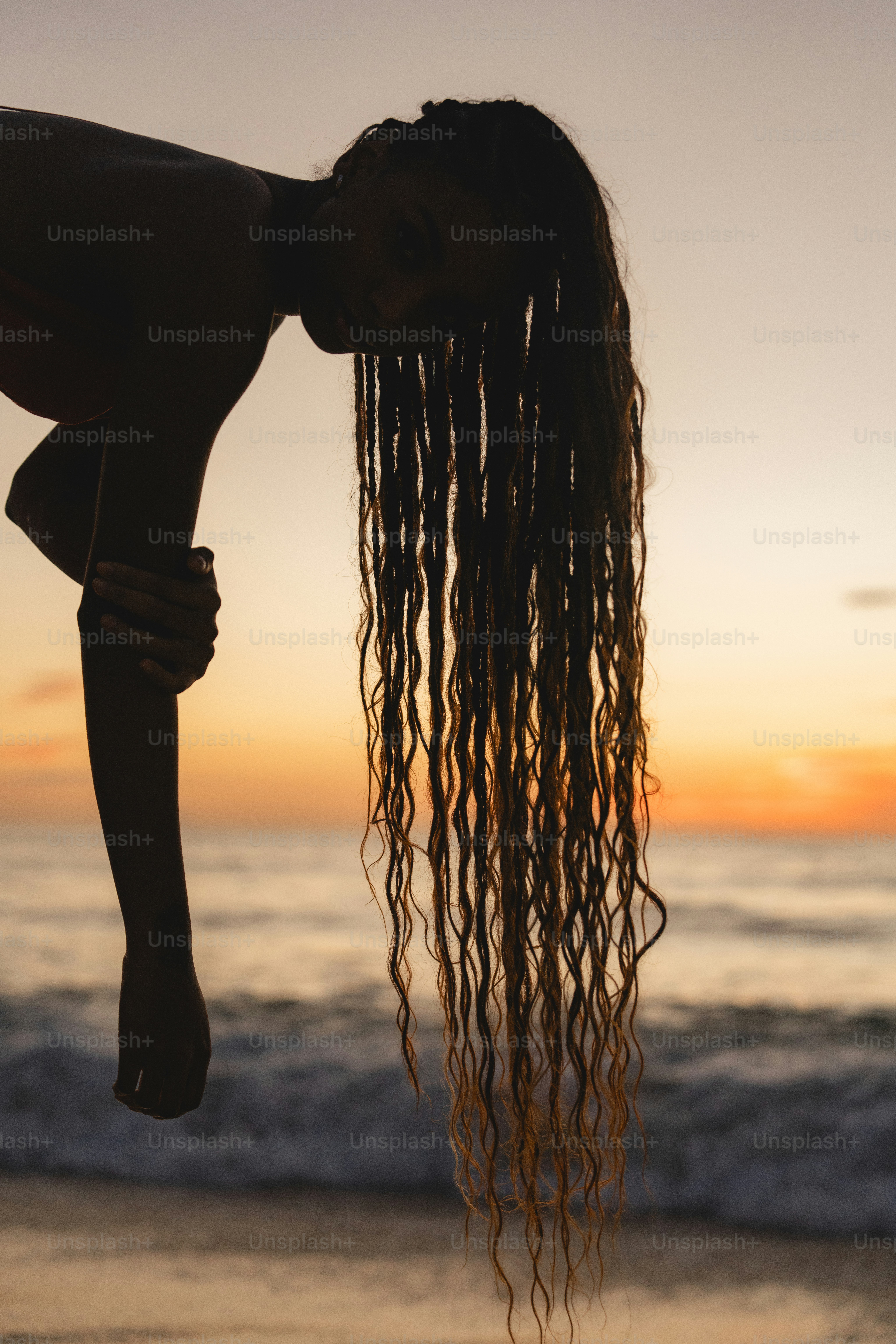 A woman standing on top of a beach next to the ocean