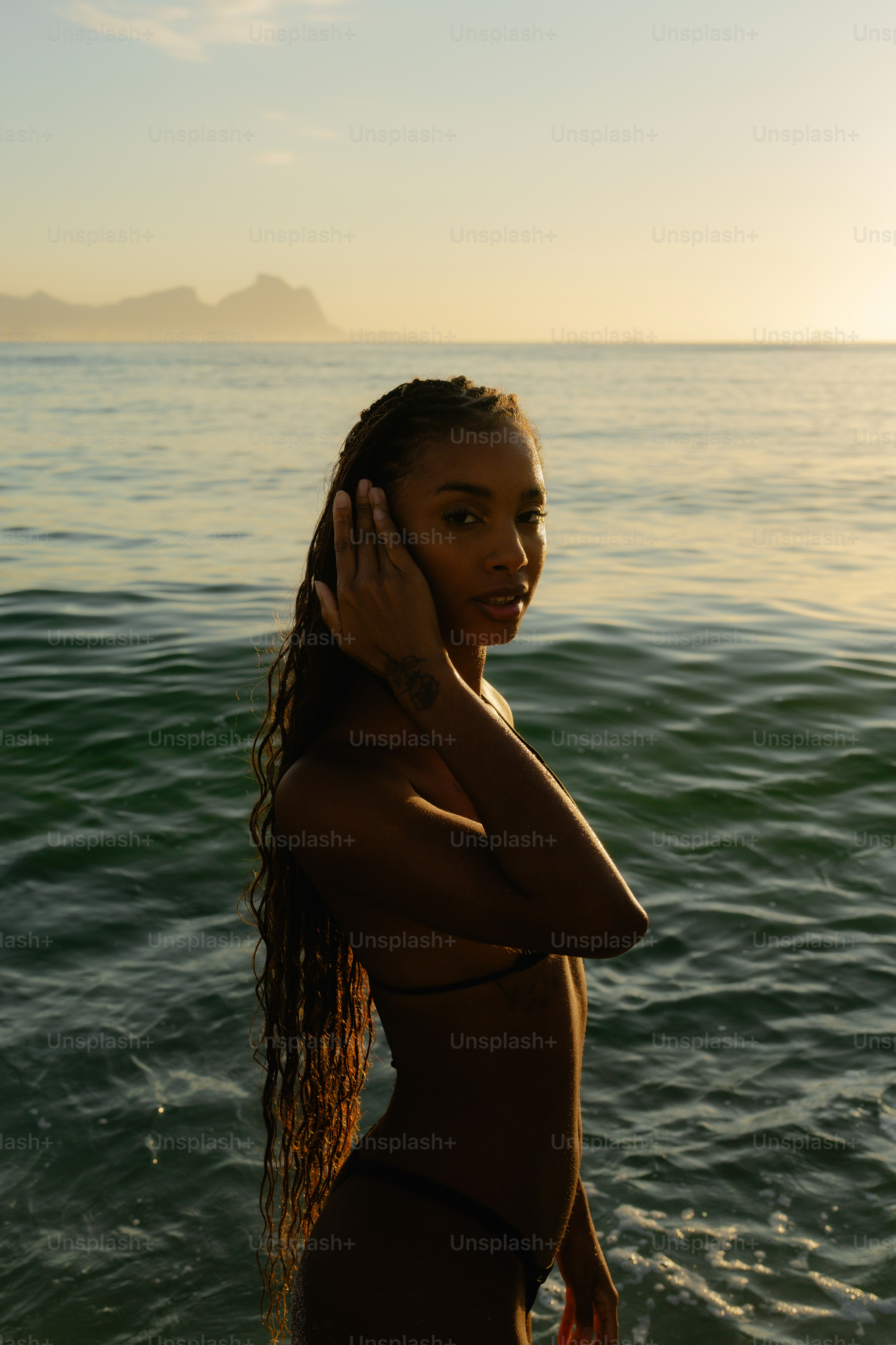 Uma mulher em pé na água com um telefone celular no ouvido