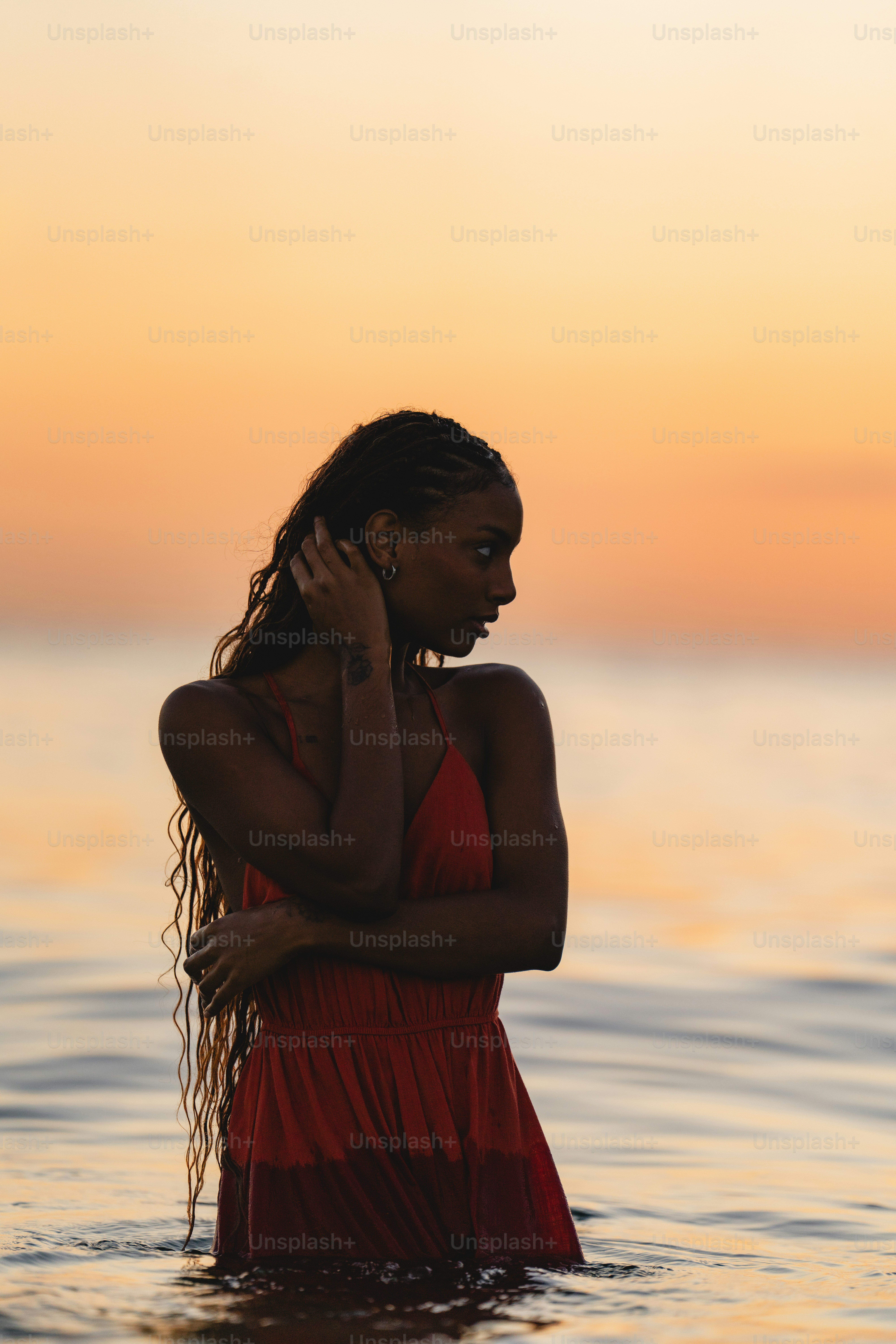 A woman in a red dress standing in the water