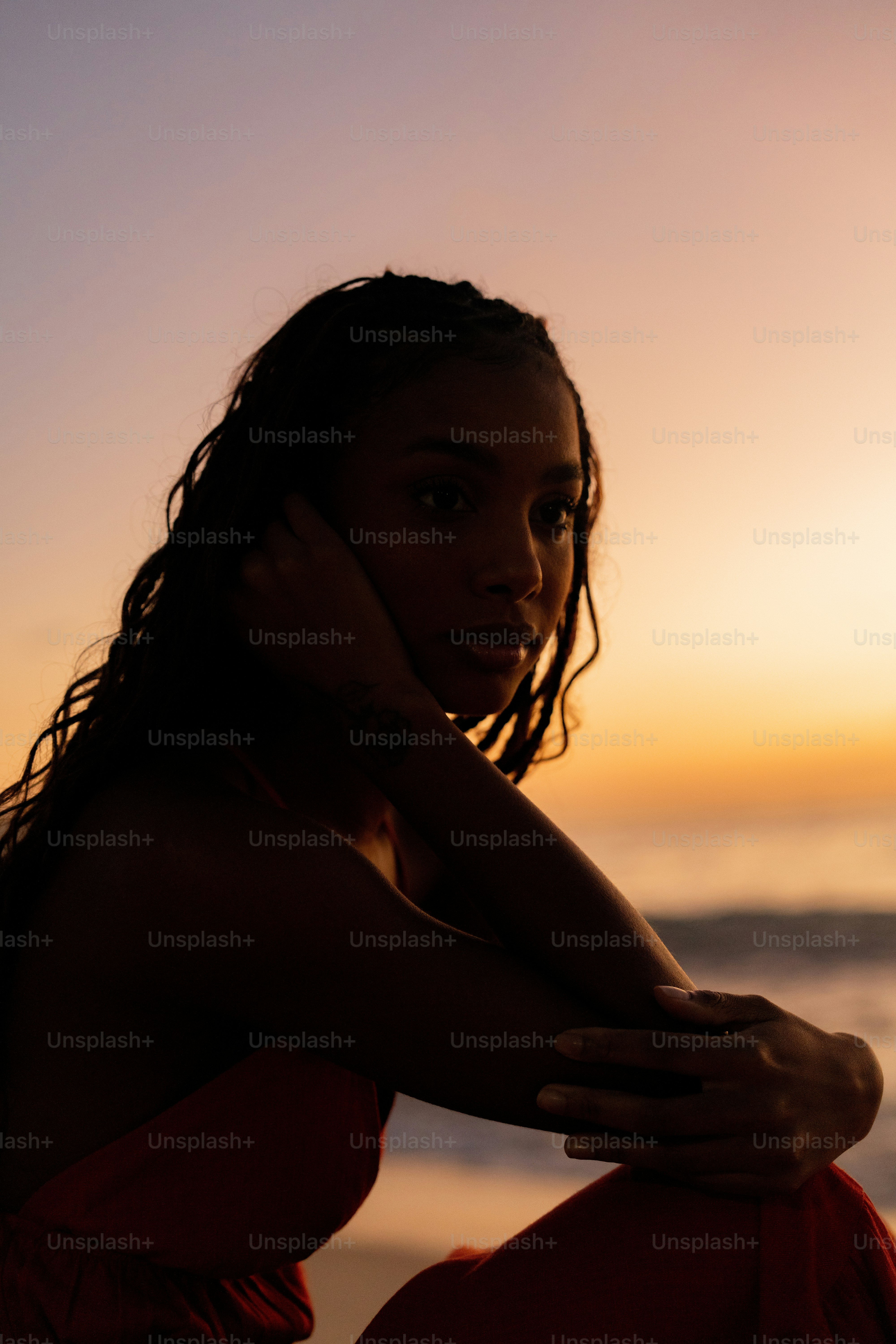 A woman in a red dress sitting on a beach